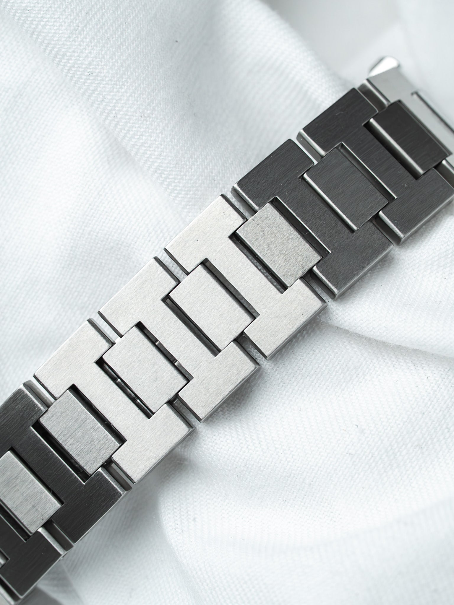 Vintage Rolex Oyster bracelet in brushed stainless steel, laid on white fabric