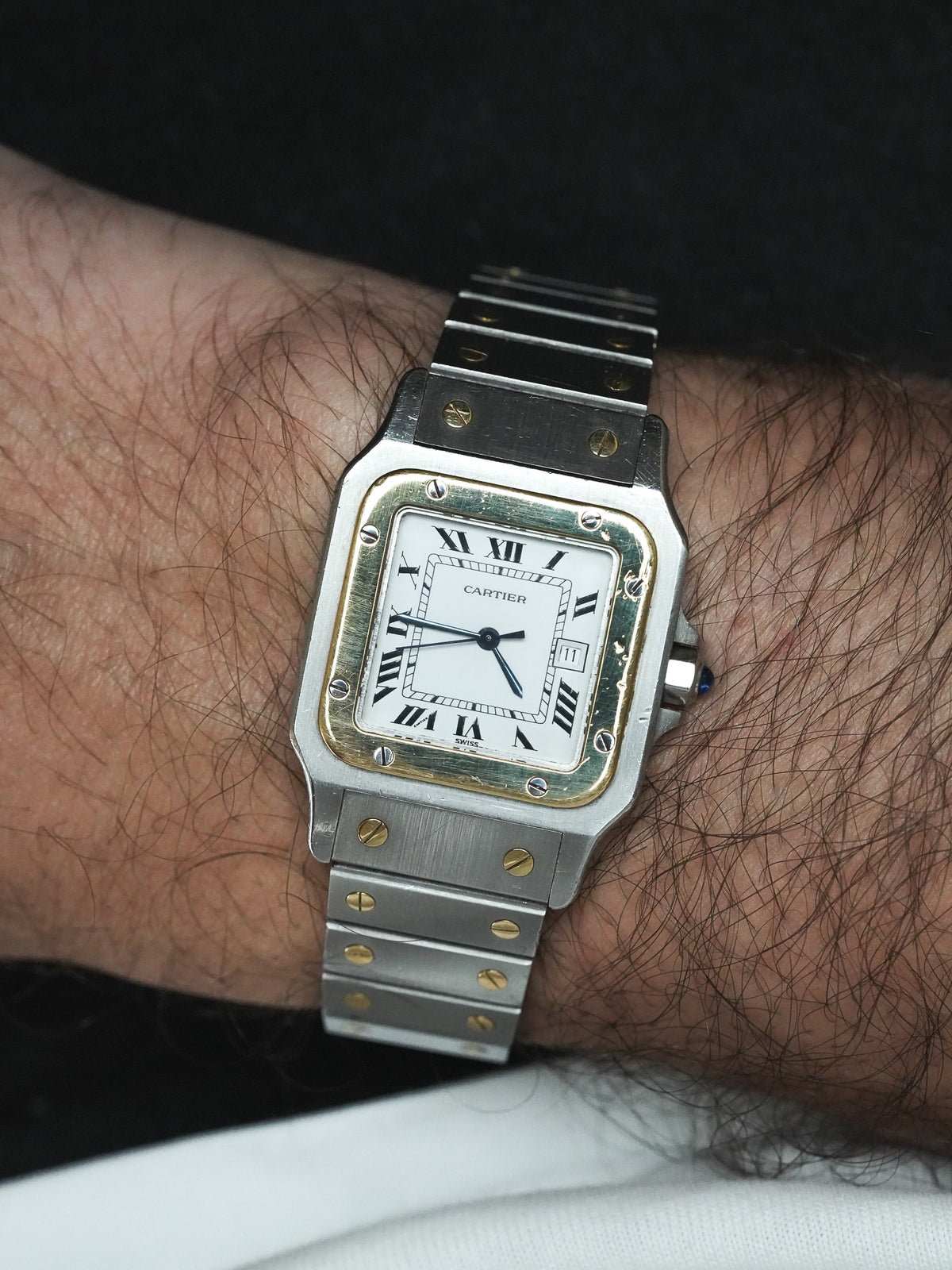 Montre portée au poignet, cadran blanc à chiffres romains - Montre Cartier Santos Carrée 2961 Vintage - Atelier Victor