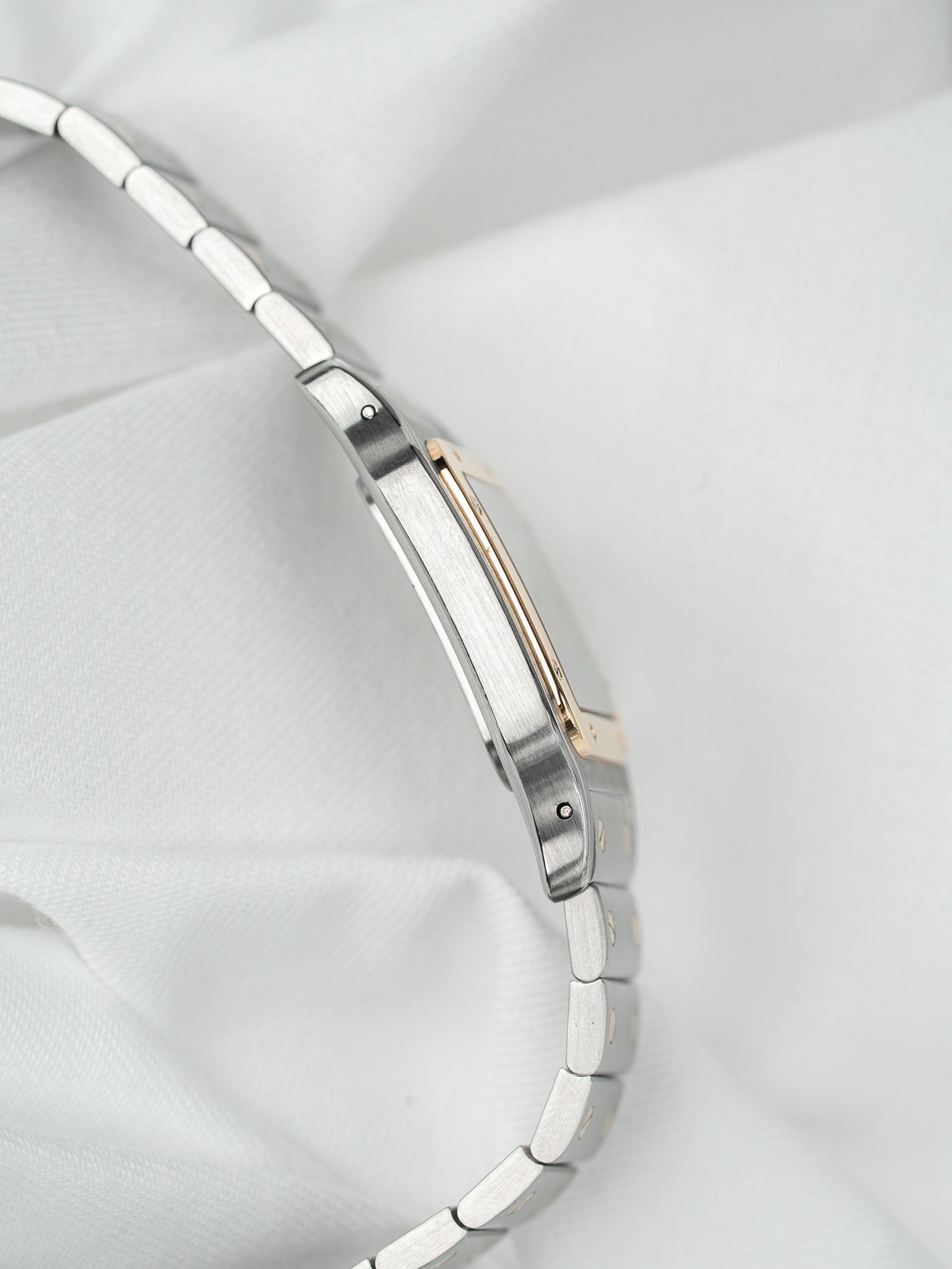 Cartier Tank vintage watch with two-tone steel and gold bracelet on white fabric