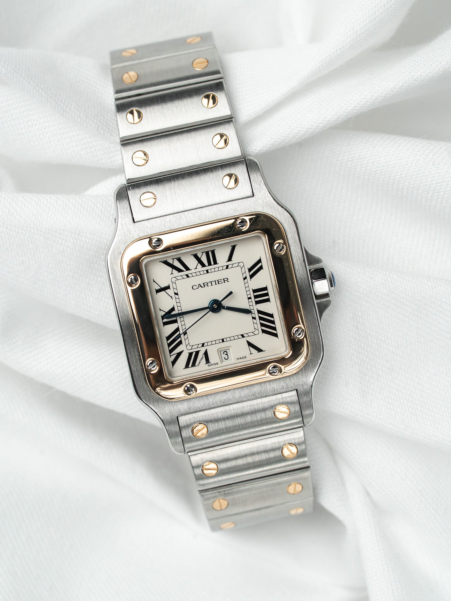 Cartier Santos watch with steel and gold case, white dial, Roman numerals on white fabric