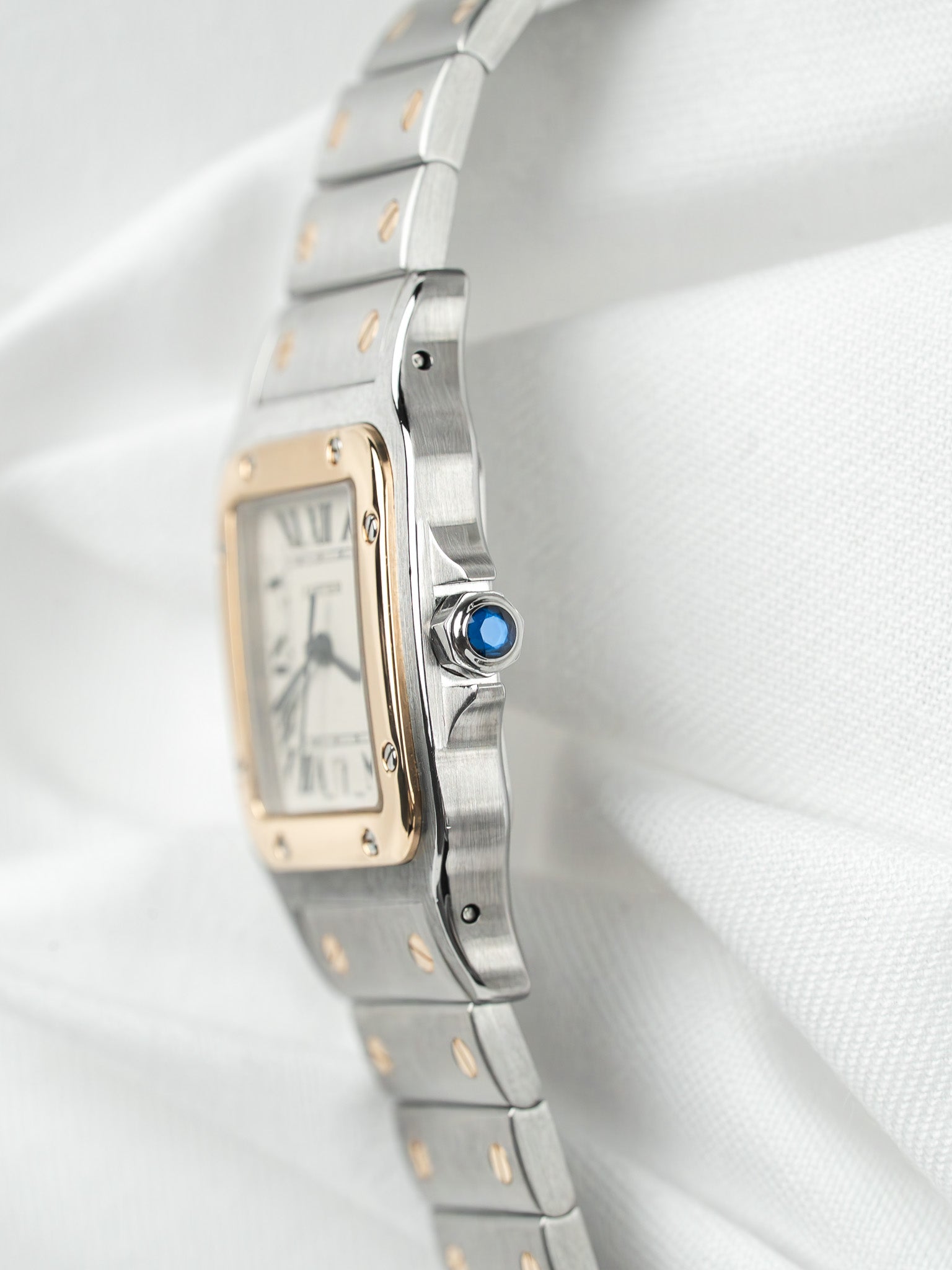 Cartier Santos watch with two-tone steel and gold bracelet, blue cabochon crown, white dial