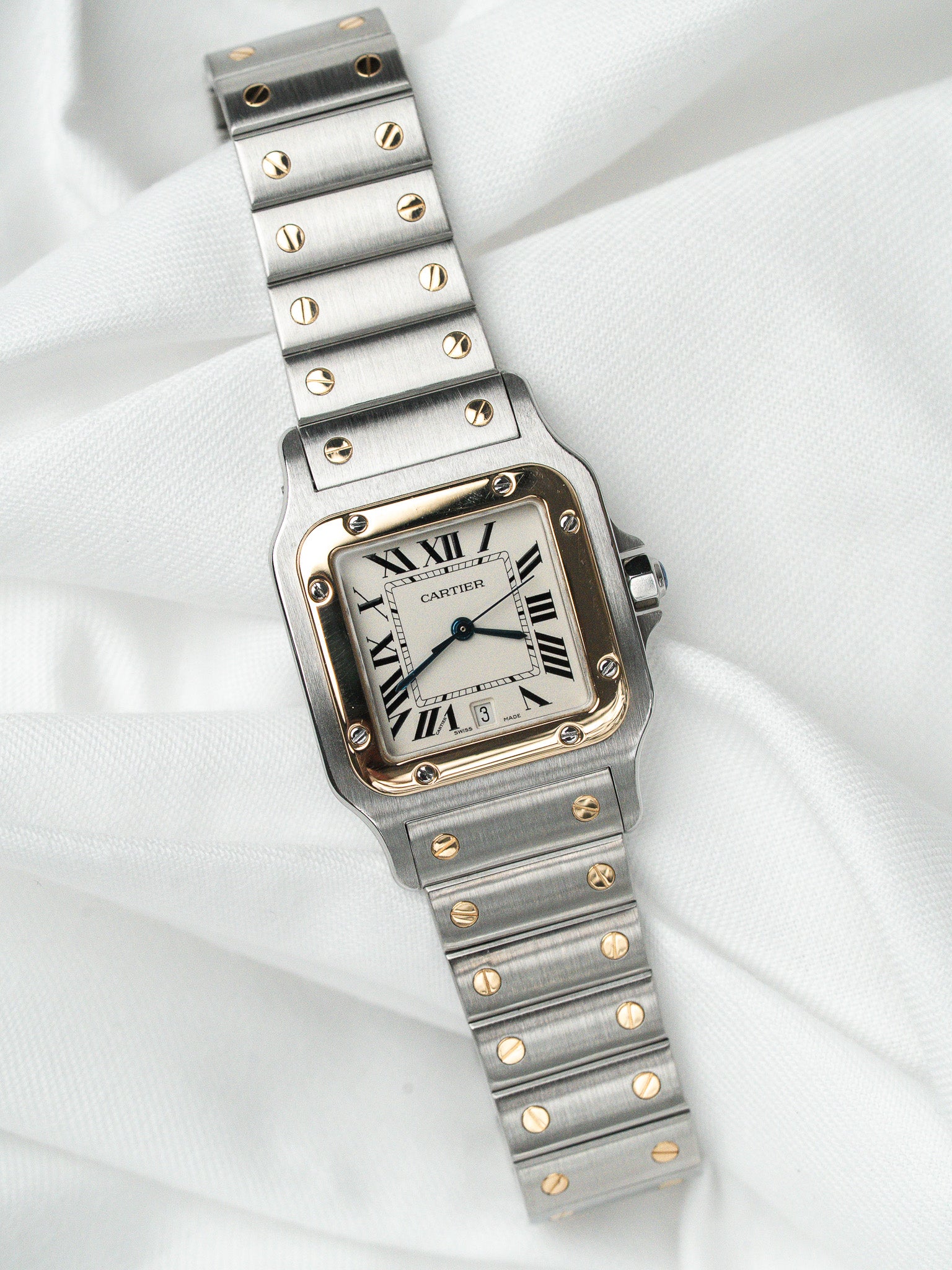 Cartier Santos watch with steel and gold bracelet, white dial, Roman numerals on white fabric