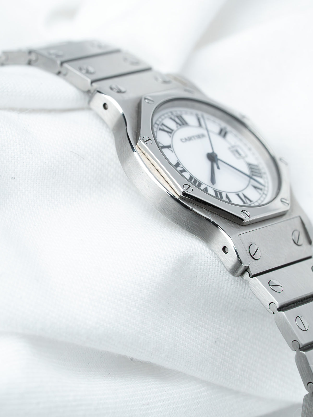 Cartier Santos watch with white dial, Roman numerals, and steel bracelet