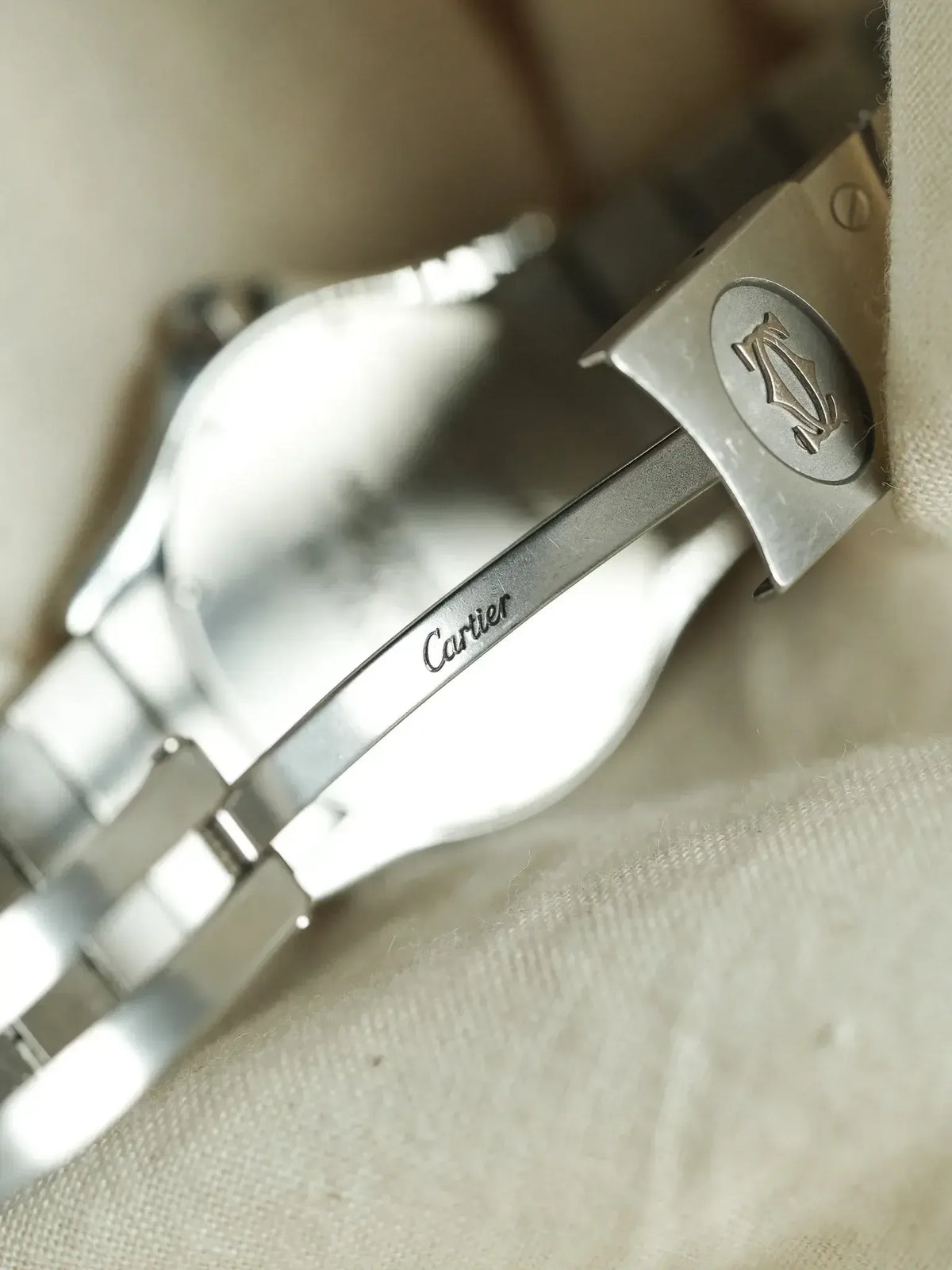 Cartier watch bracelet with engraved logo and stainless steel clasp on fabric