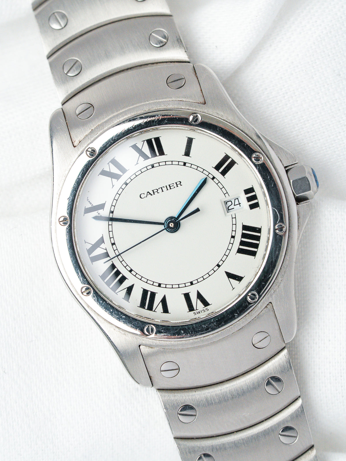 Cartier watch with white dial, Roman numerals, stainless steel bracelet on white background