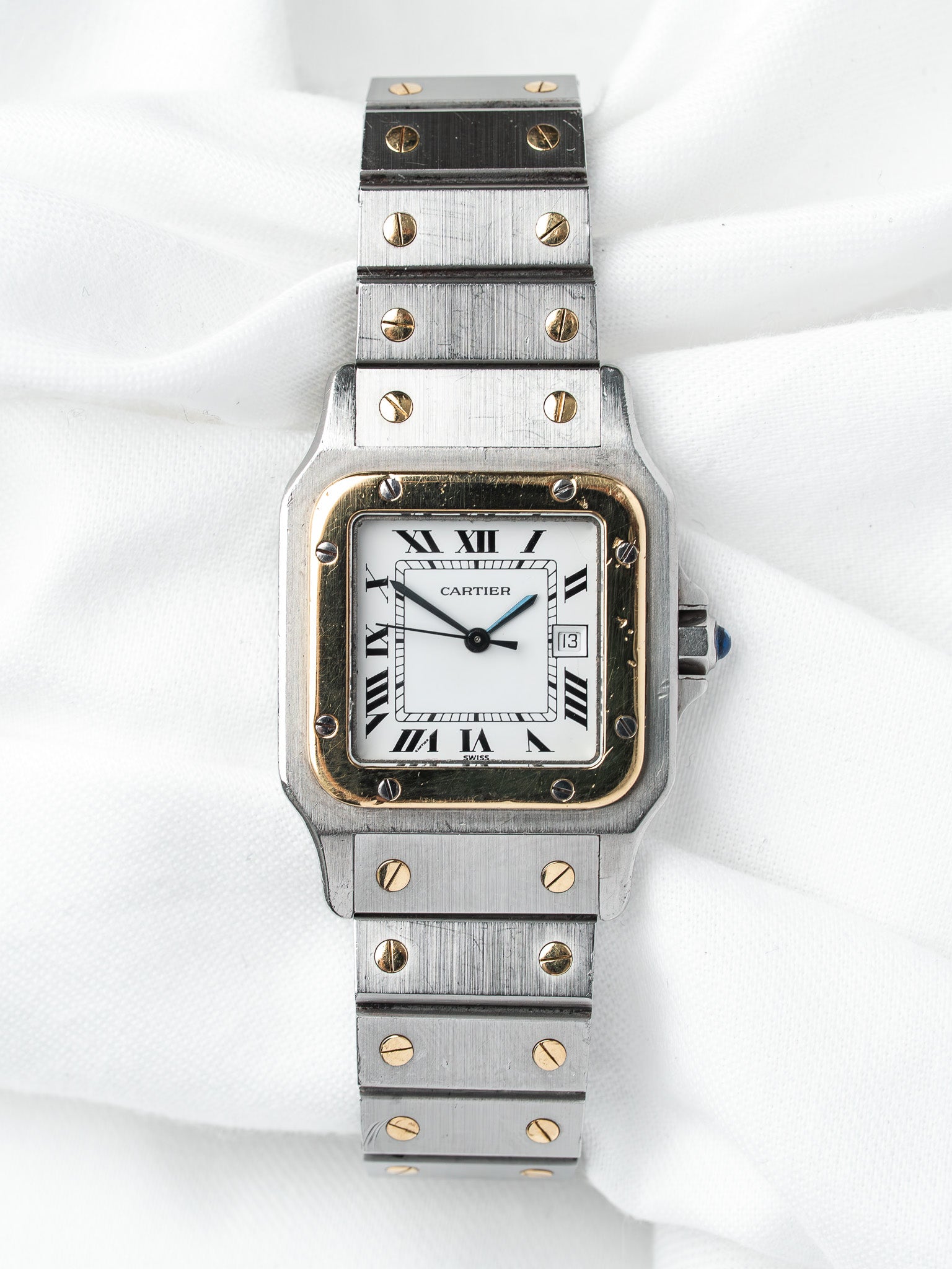 Cartier Santos vintage watch with steel and gold case, white dial, Roman numerals on white fabric