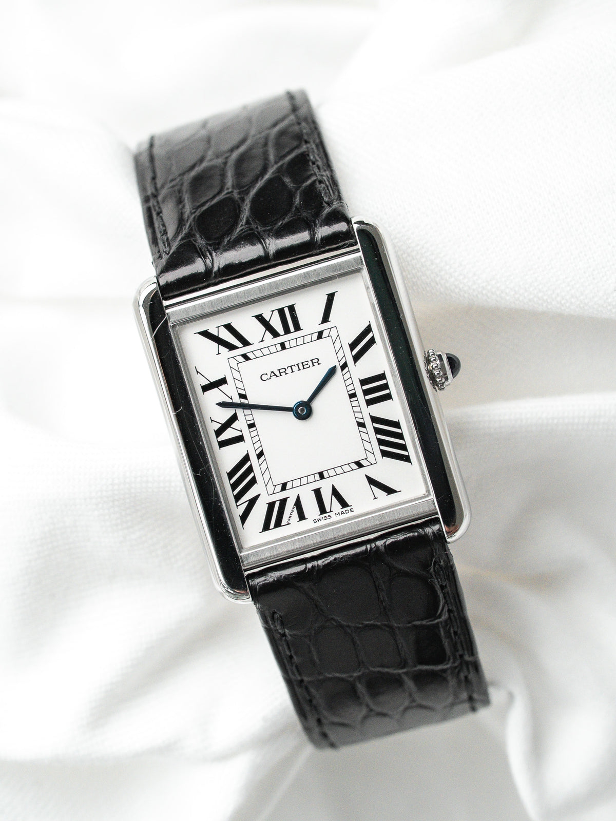 Montre Cartier Tank vintage, boîtier rectangulaire argenté, cadran blanc et bracelet cuir noir