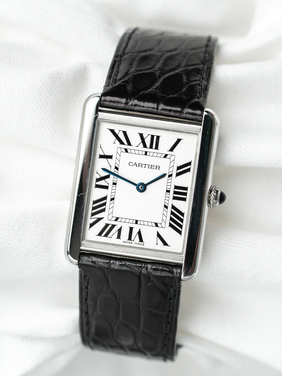 Montre Cartier Tank vintage, boîtier rectangulaire acier, cadran blanc et bracelet cuir noir