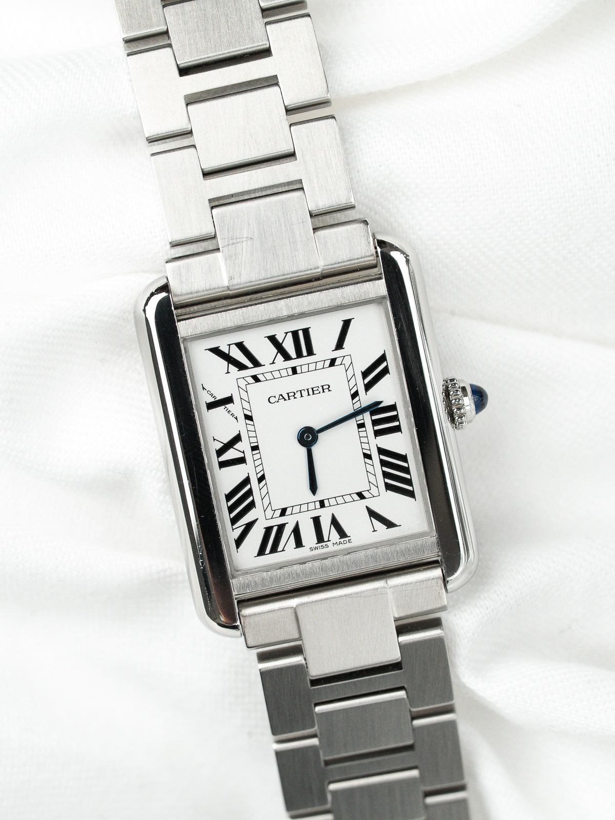 Montre Cartier vintage en acier, boîtier rectangulaire et cadran blanc, sur fond blanc