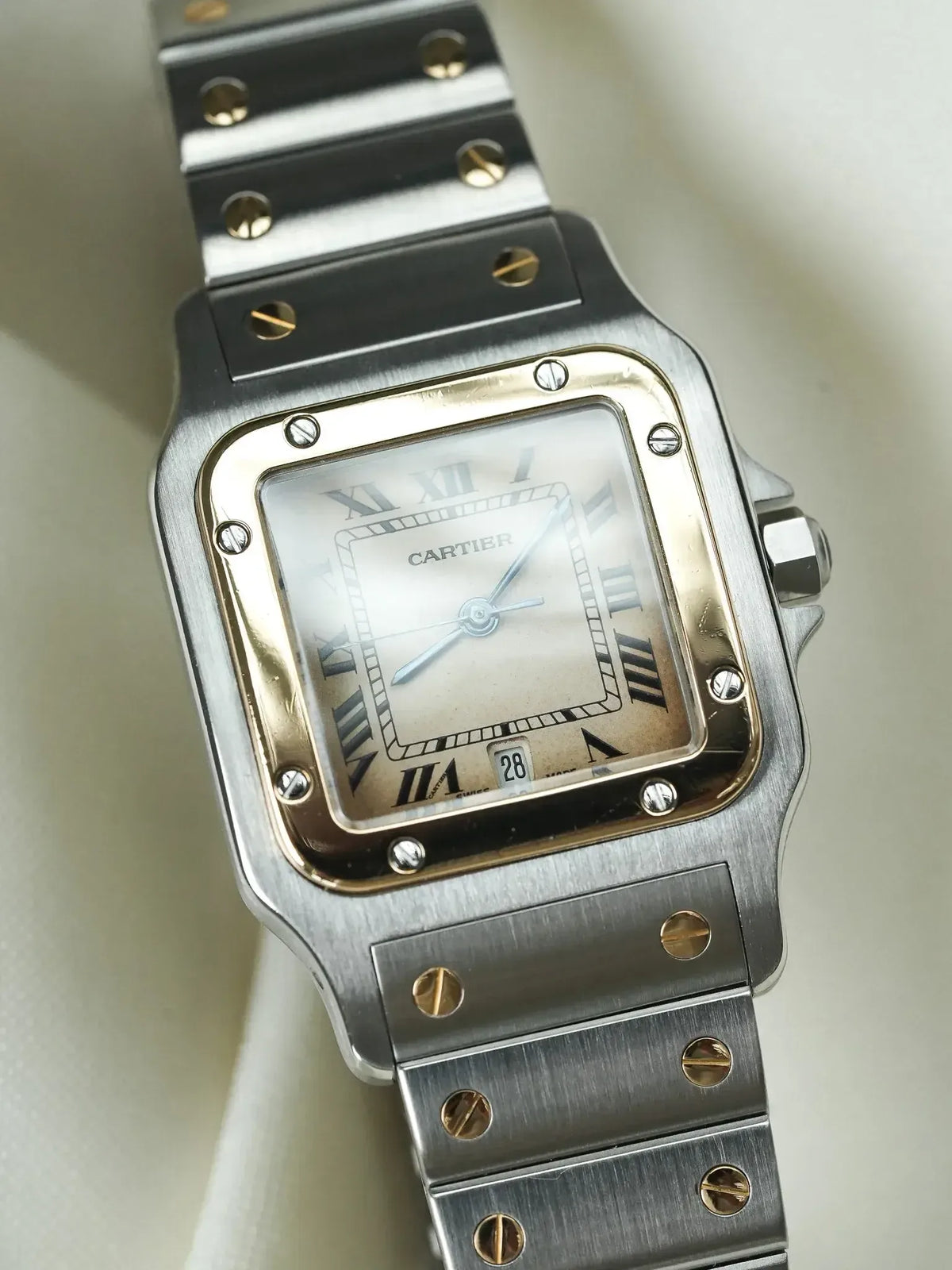 Cartier Santos vintage watch with silver dial, gold accents, and steel bracelet