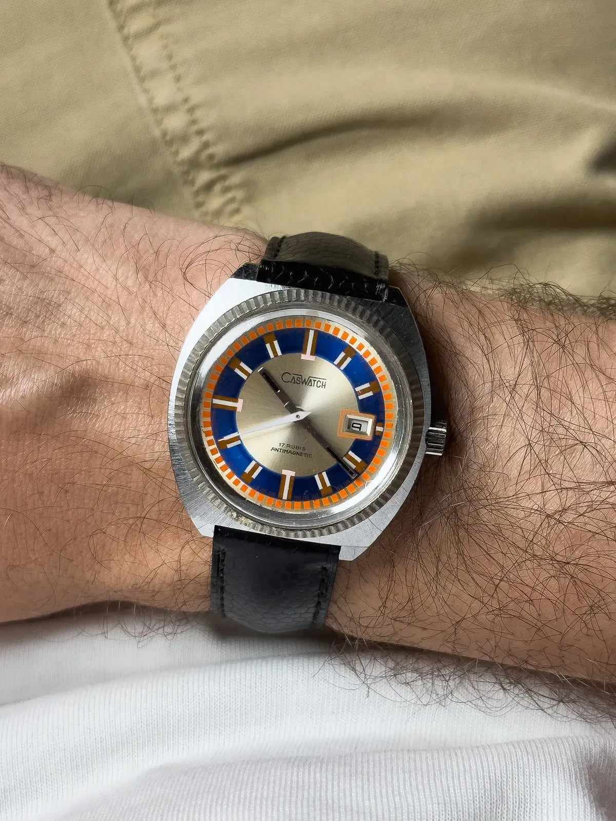 Caswatch vintage watch with blue and orange dial, black leather strap, worn on wrist