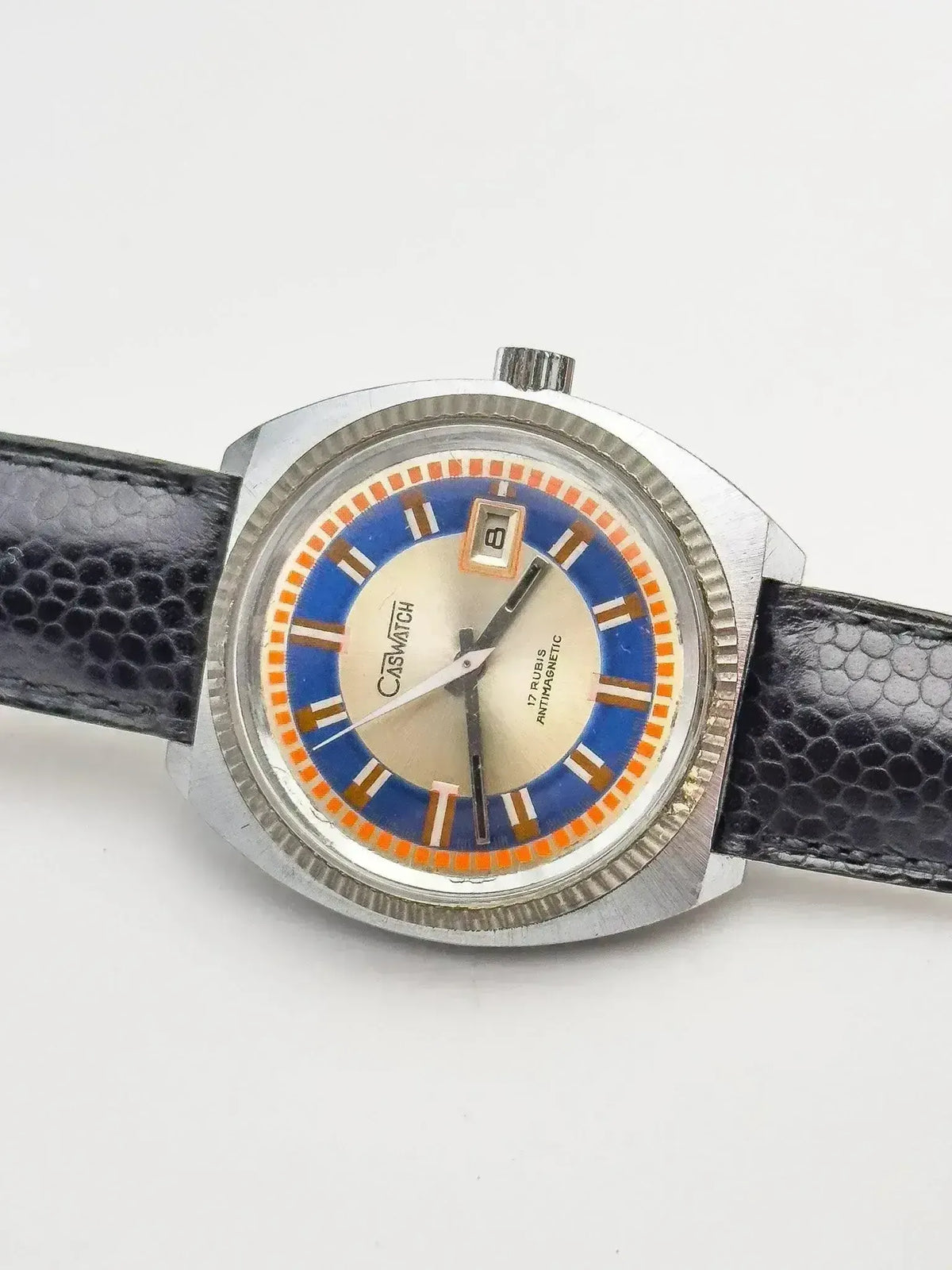 Vintage Casio watch with blue and orange dial, black textured strap, silver case
