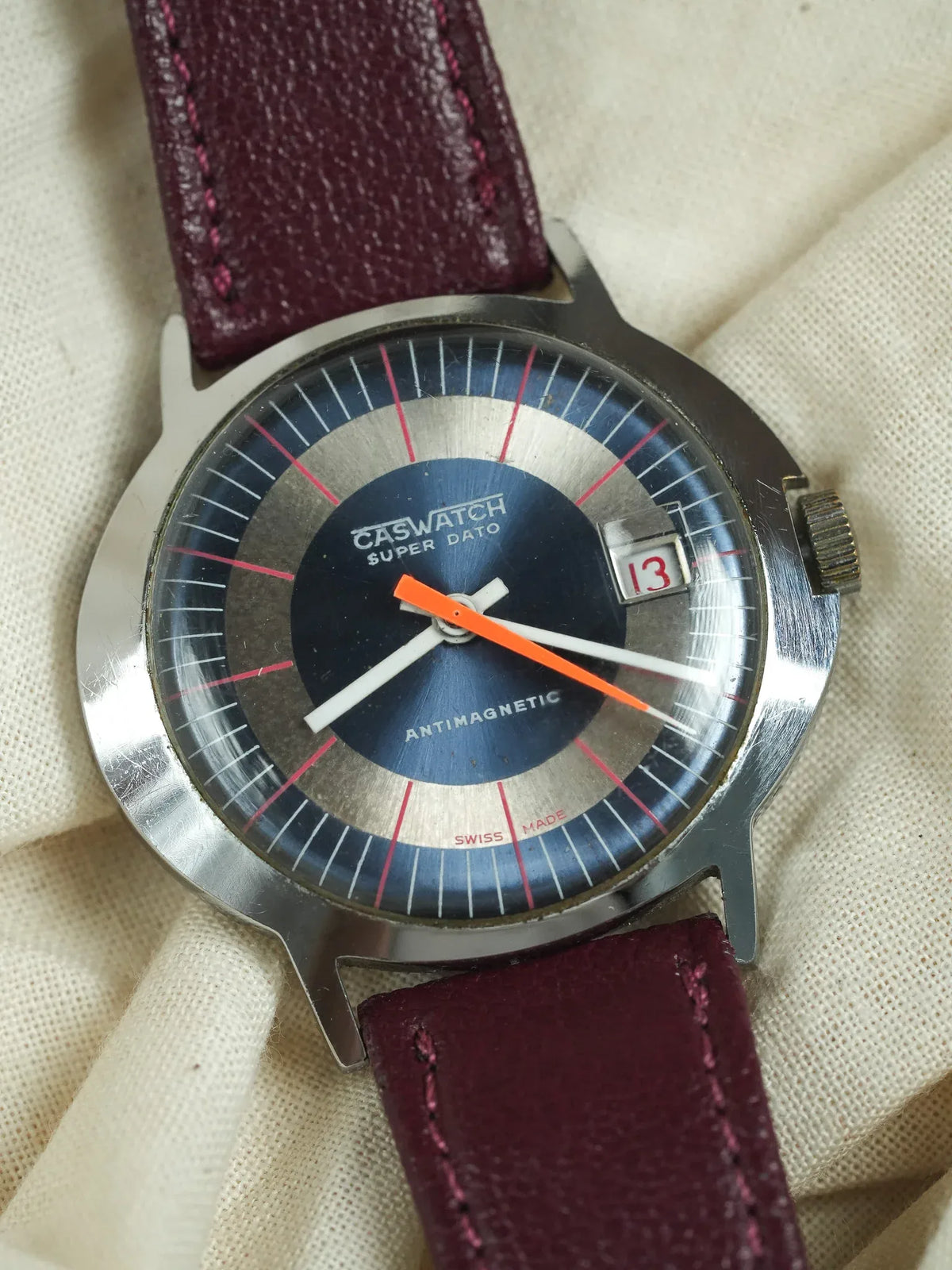 Caswatch Super Dato vintage watch with blue dial, orange second hand, burgundy leather strap