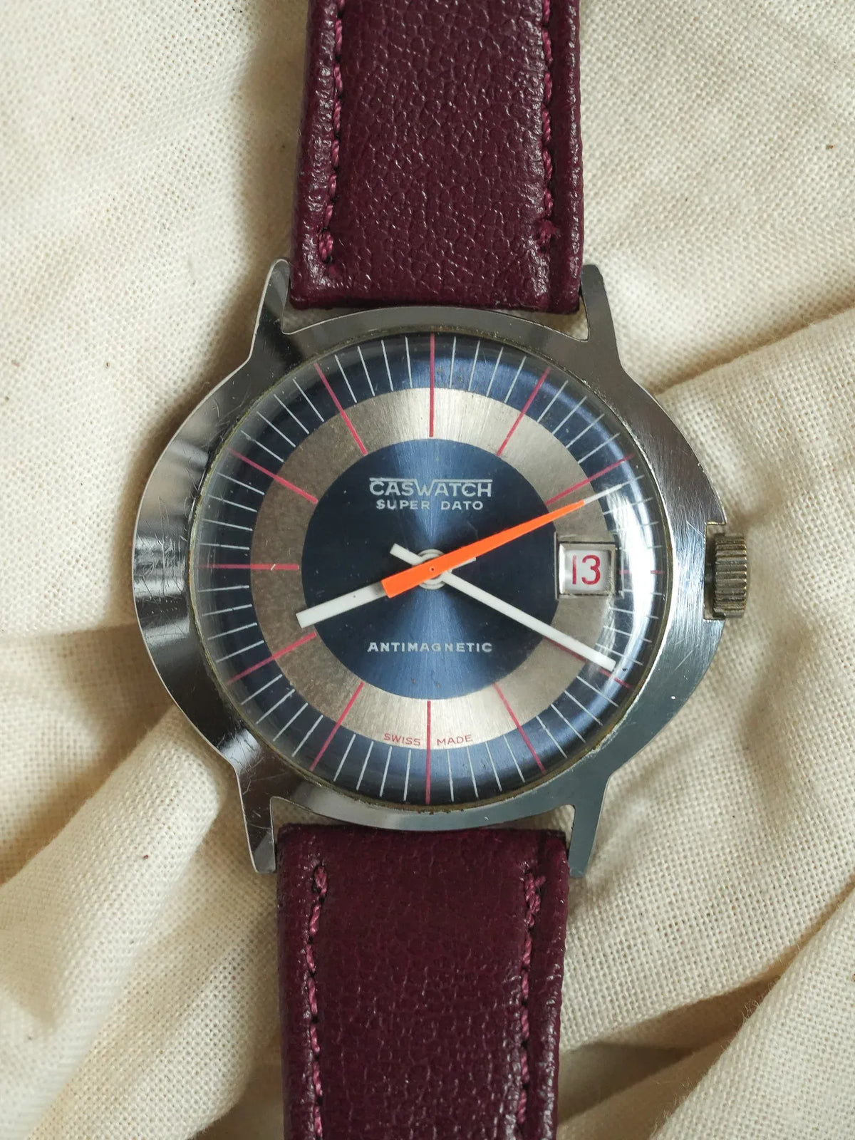 Caswatch Super Dato vintage watch with blue dial, orange second hand, burgundy leather strap