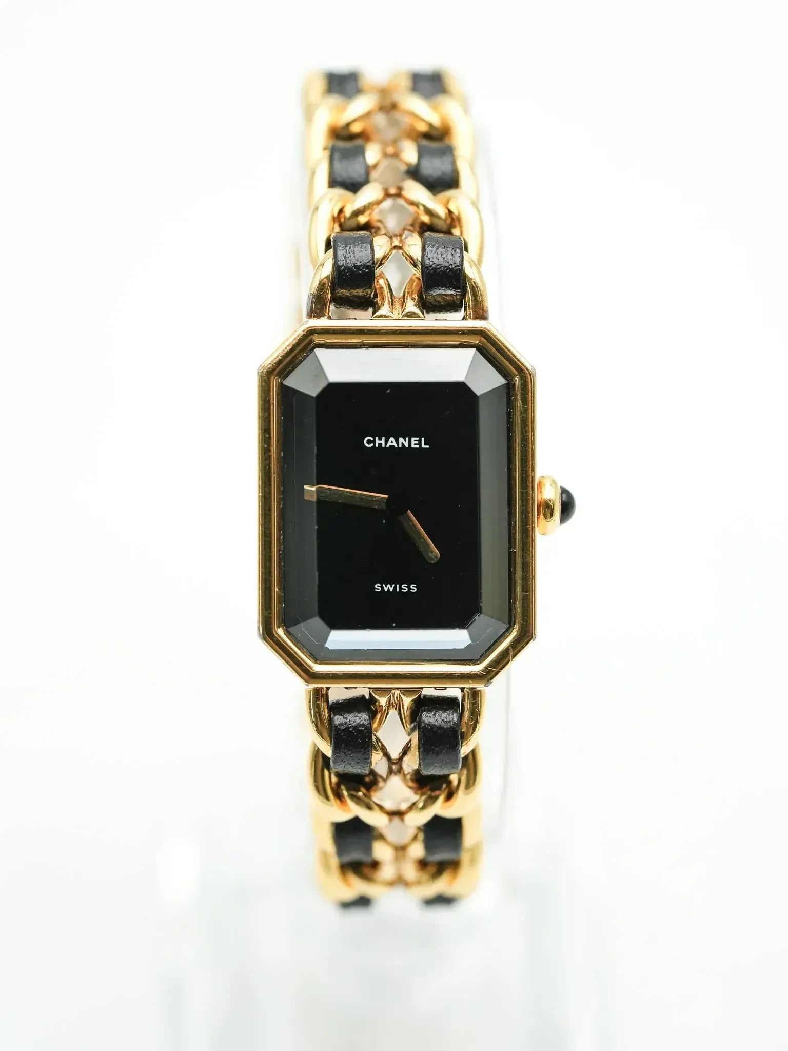 Chanel vintage watch with black dial, gold case, and black leather bracelet on white background
