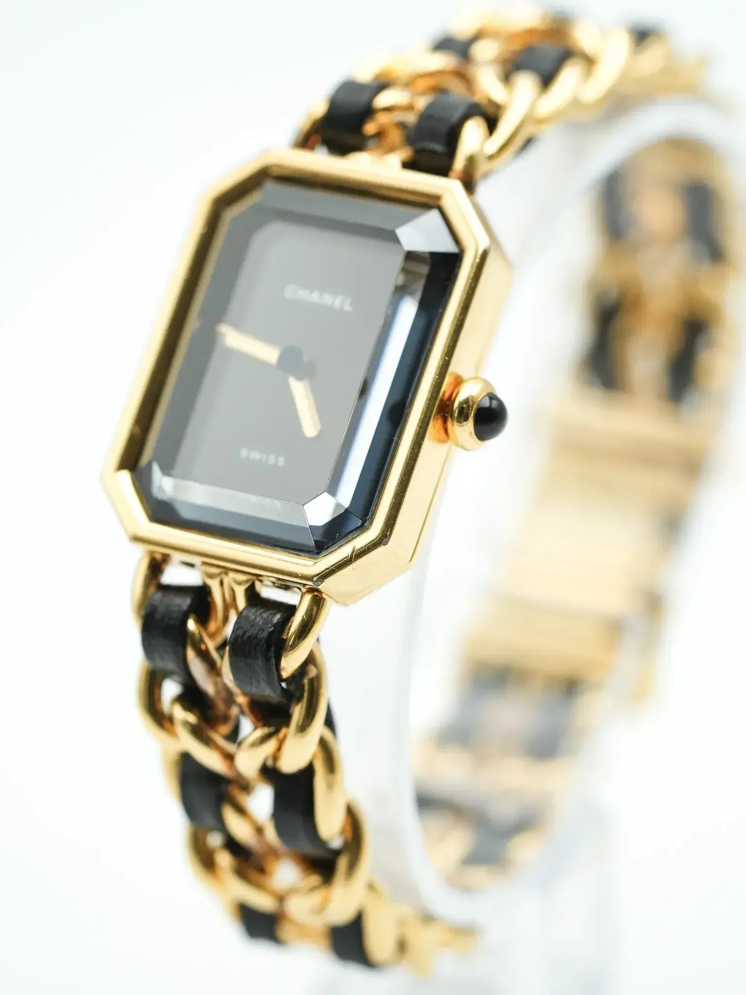 Chanel vintage watch with gold octagonal case, black dial, and chain bracelet