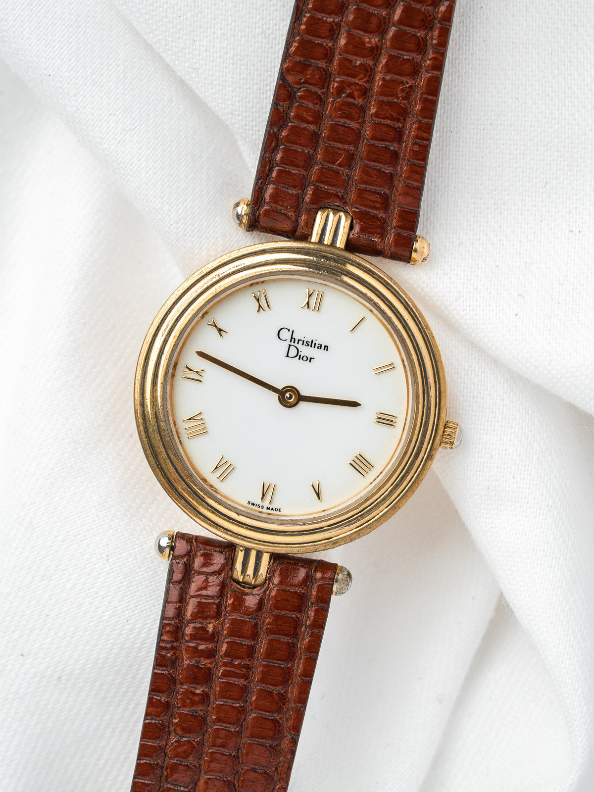 Montre Christian Dior vintage, boîtier rond doré, cadran blanc et bracelet cuir marron