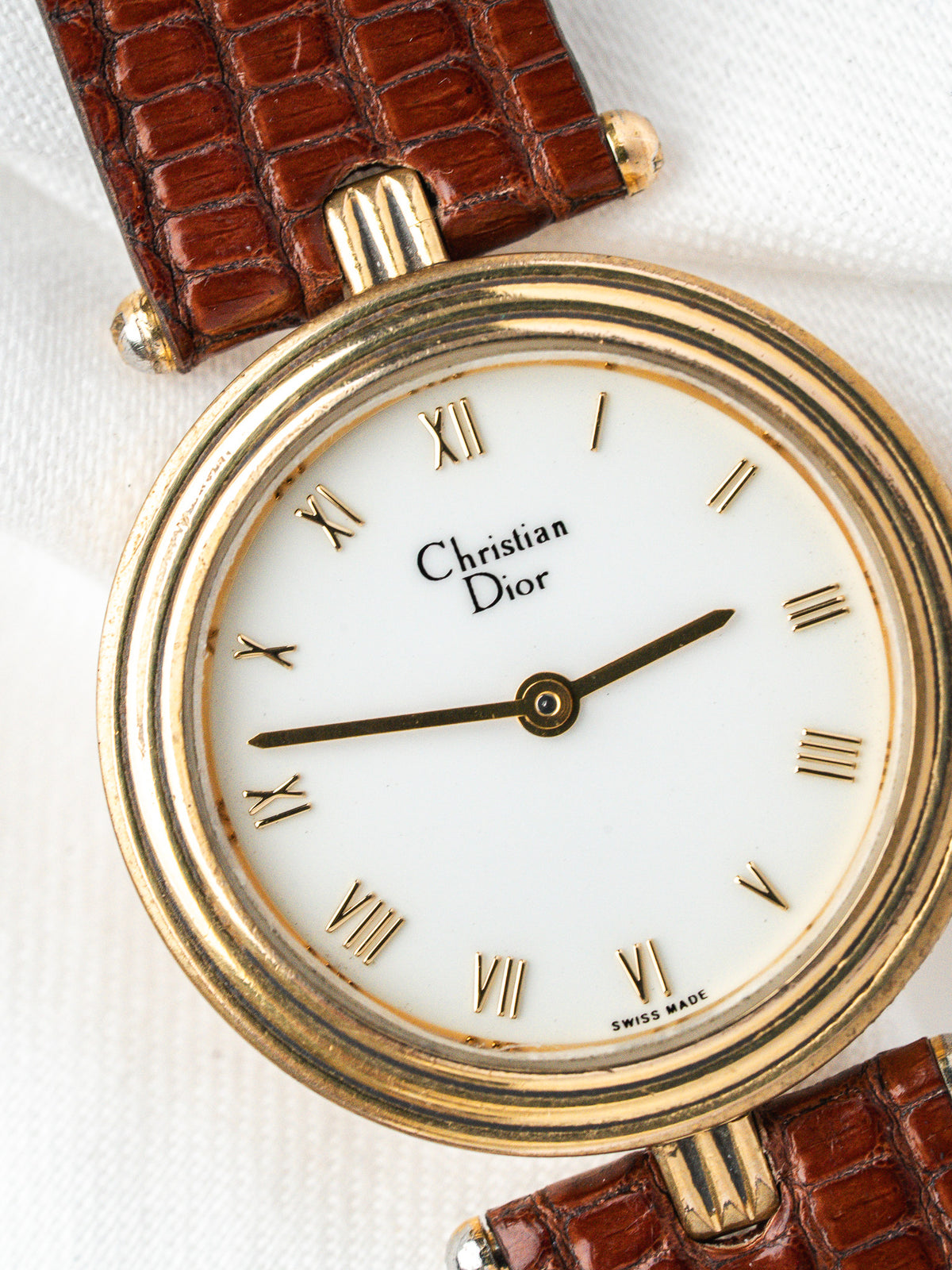 Montre Christian Dior vintage, boîtier rond plaqué or, cadran blanc et bracelet cuir marron