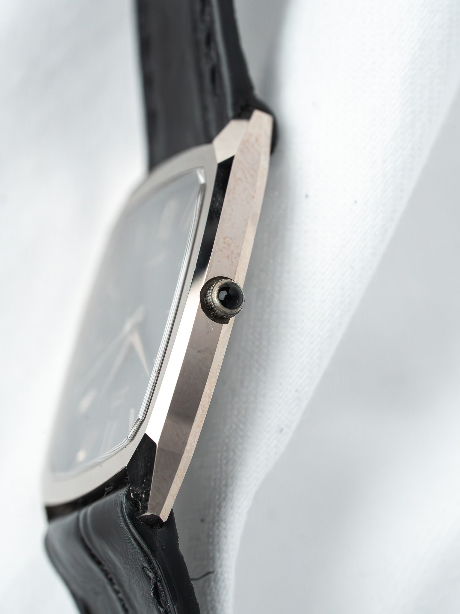 Vintage Cartier Tank watch with silver case, black leather strap, and crown detail