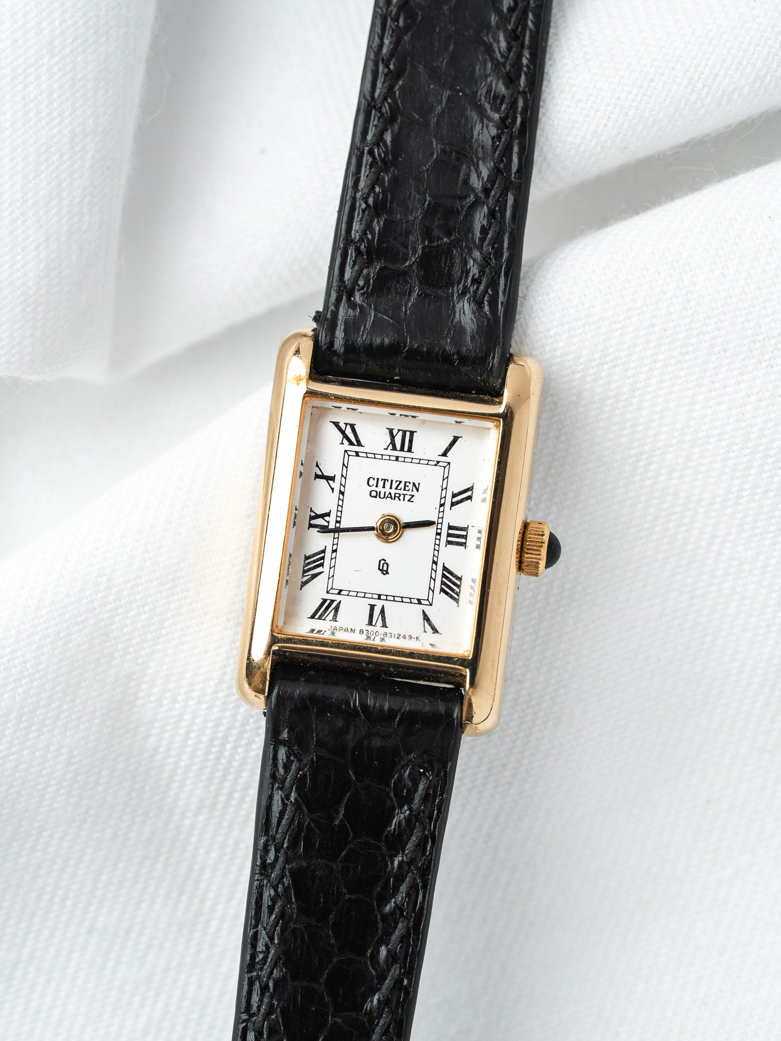 Citizen Quartz vintage watch with gold case, white dial, Roman numerals, black textured strap