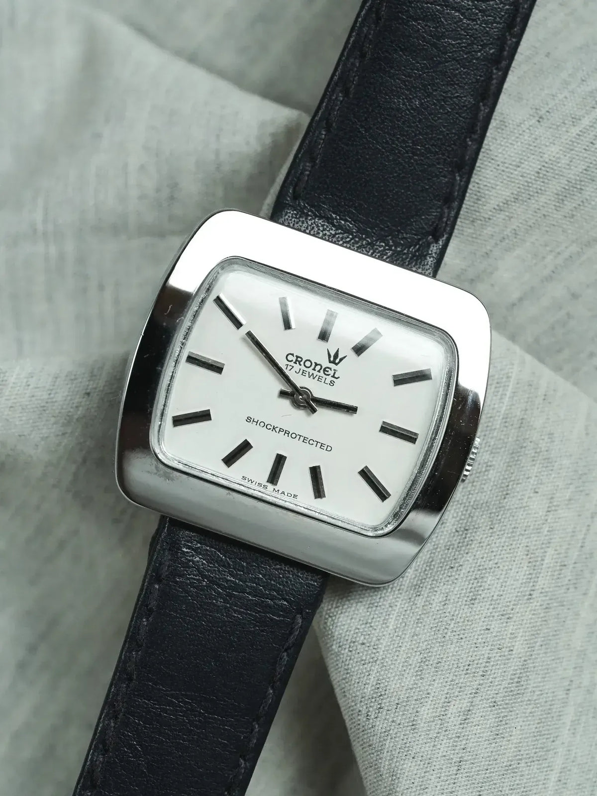 Cronel vintage watch with white dial, black leather strap, and stainless steel case