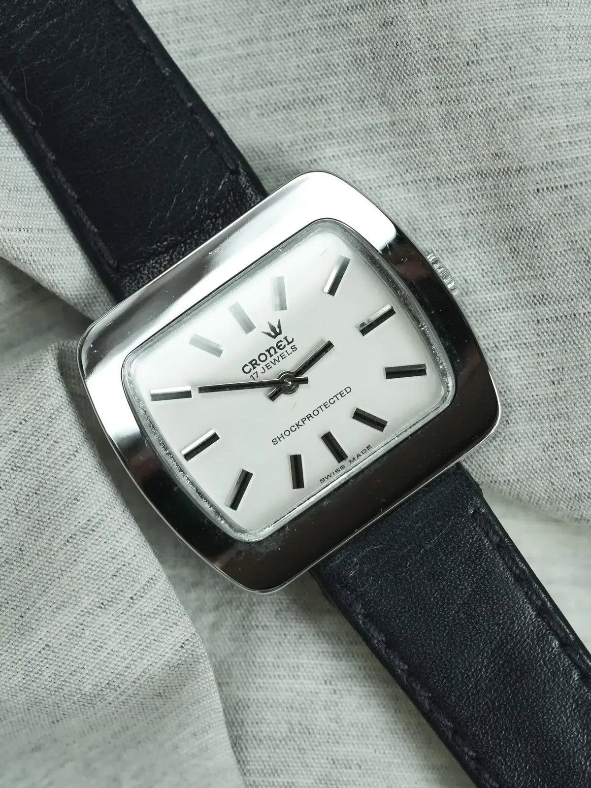 Cronel vintage watch with white dial, black markers, steel case, and black leather strap