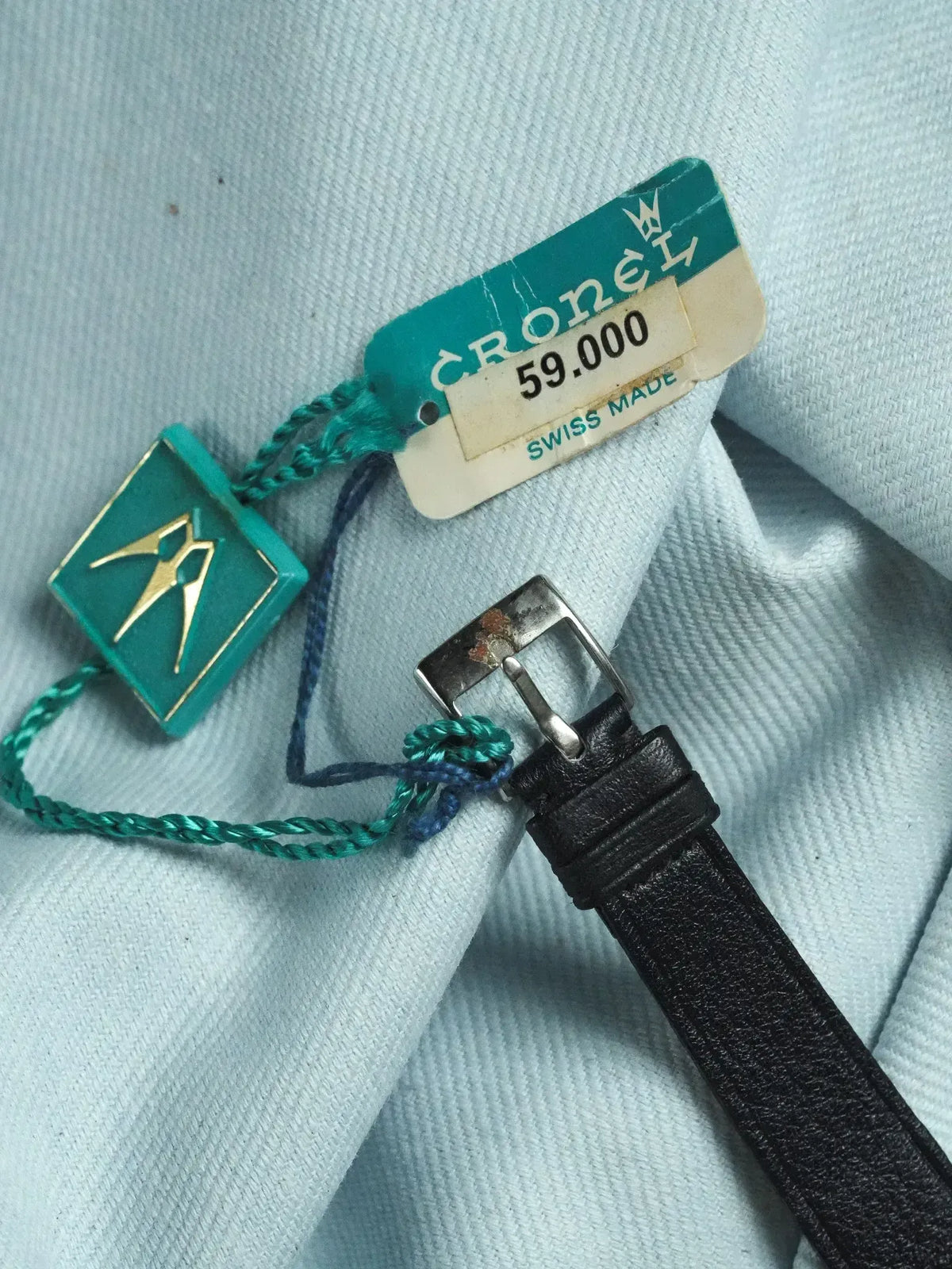 Cronel vintage watch strap with original tag, black leather, silver buckle on light fabric