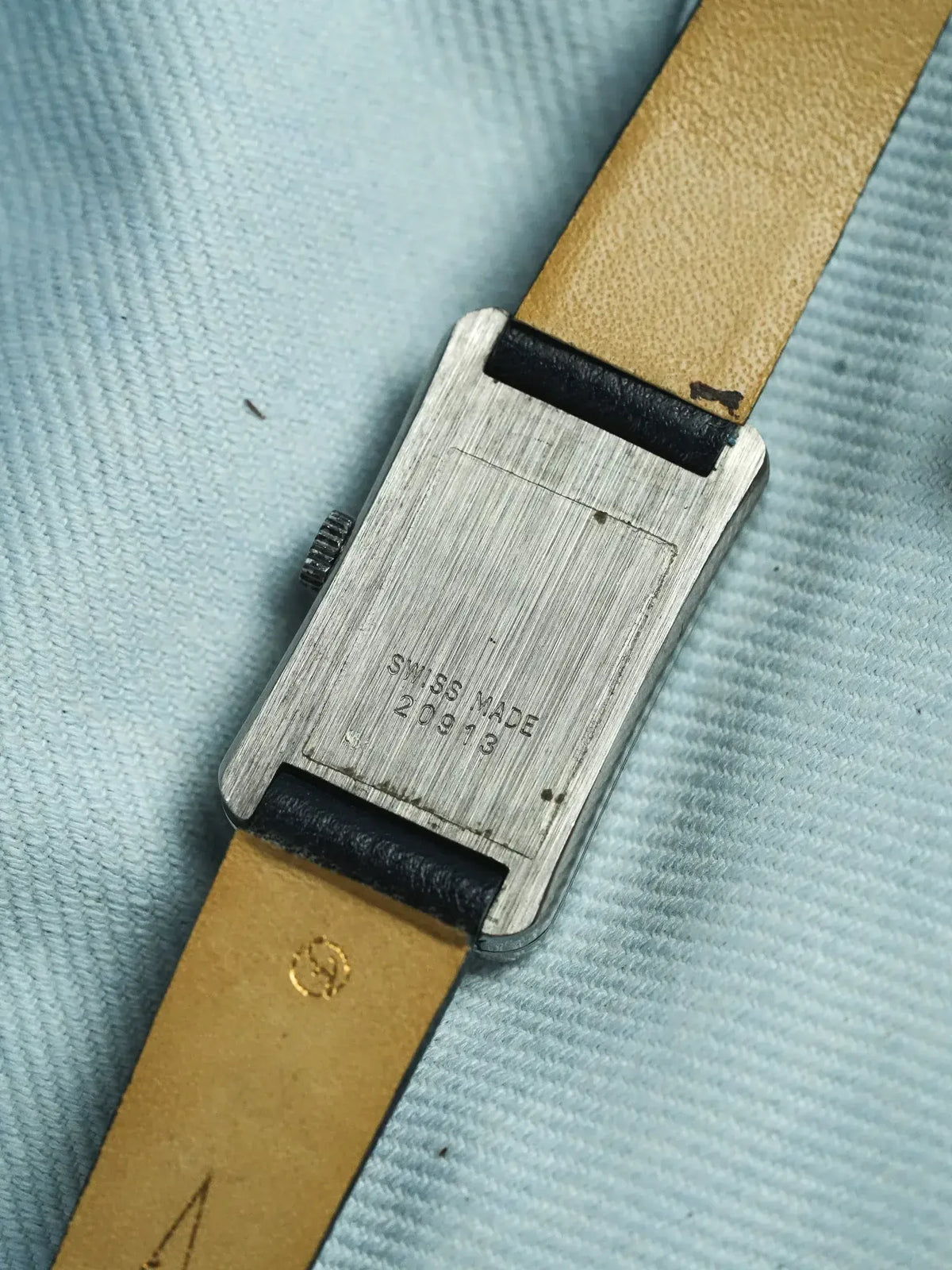 Vintage rectangular watch case back with Swiss Made engraving, tan leather strap