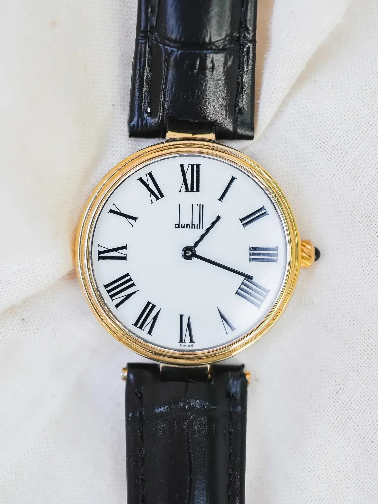 Dunhill vintage watch with gold case, white dial, Roman numerals, black leather strap