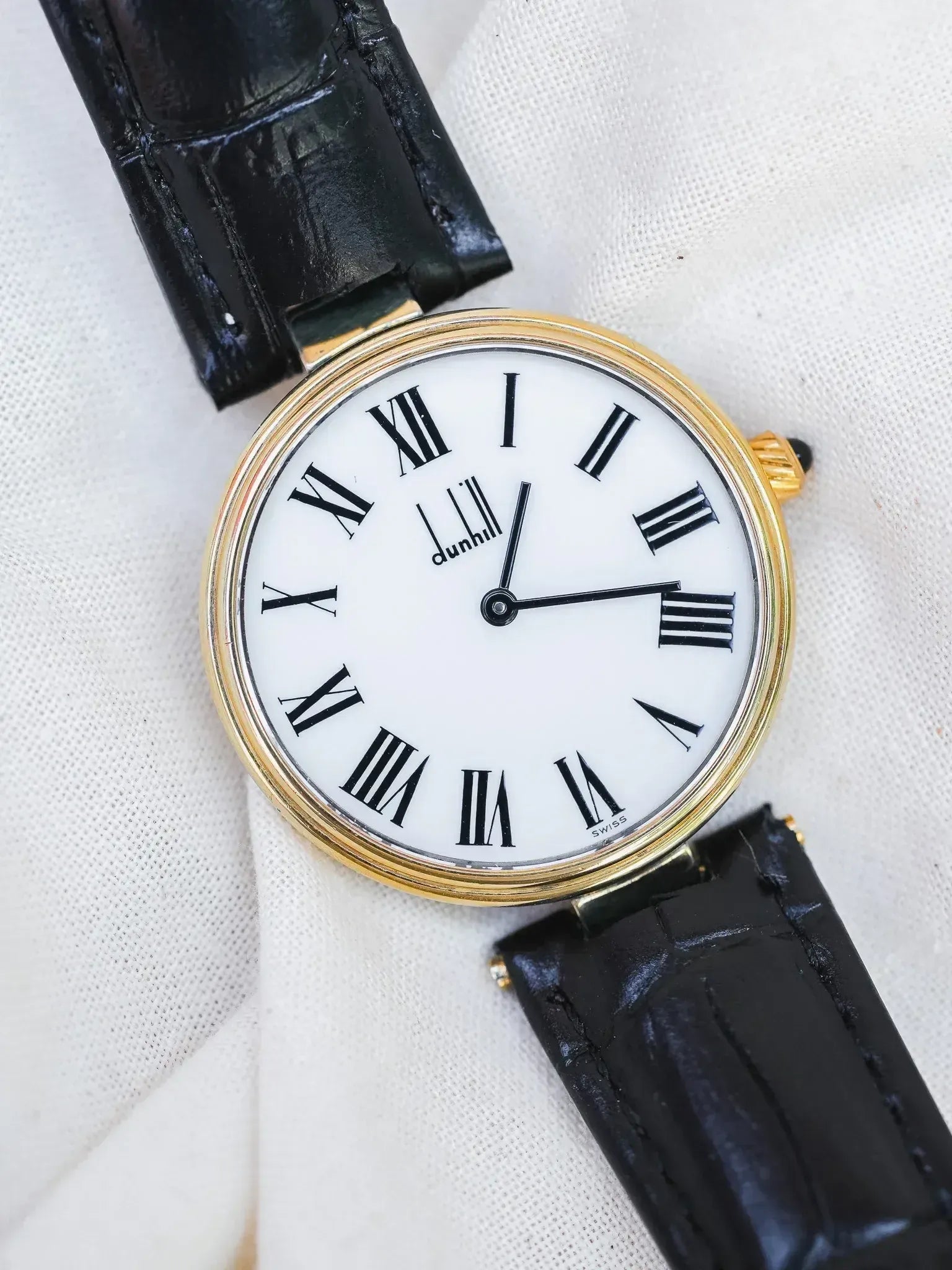 Dunhill vintage watch with gold case, white dial, Roman numerals, black alligator strap