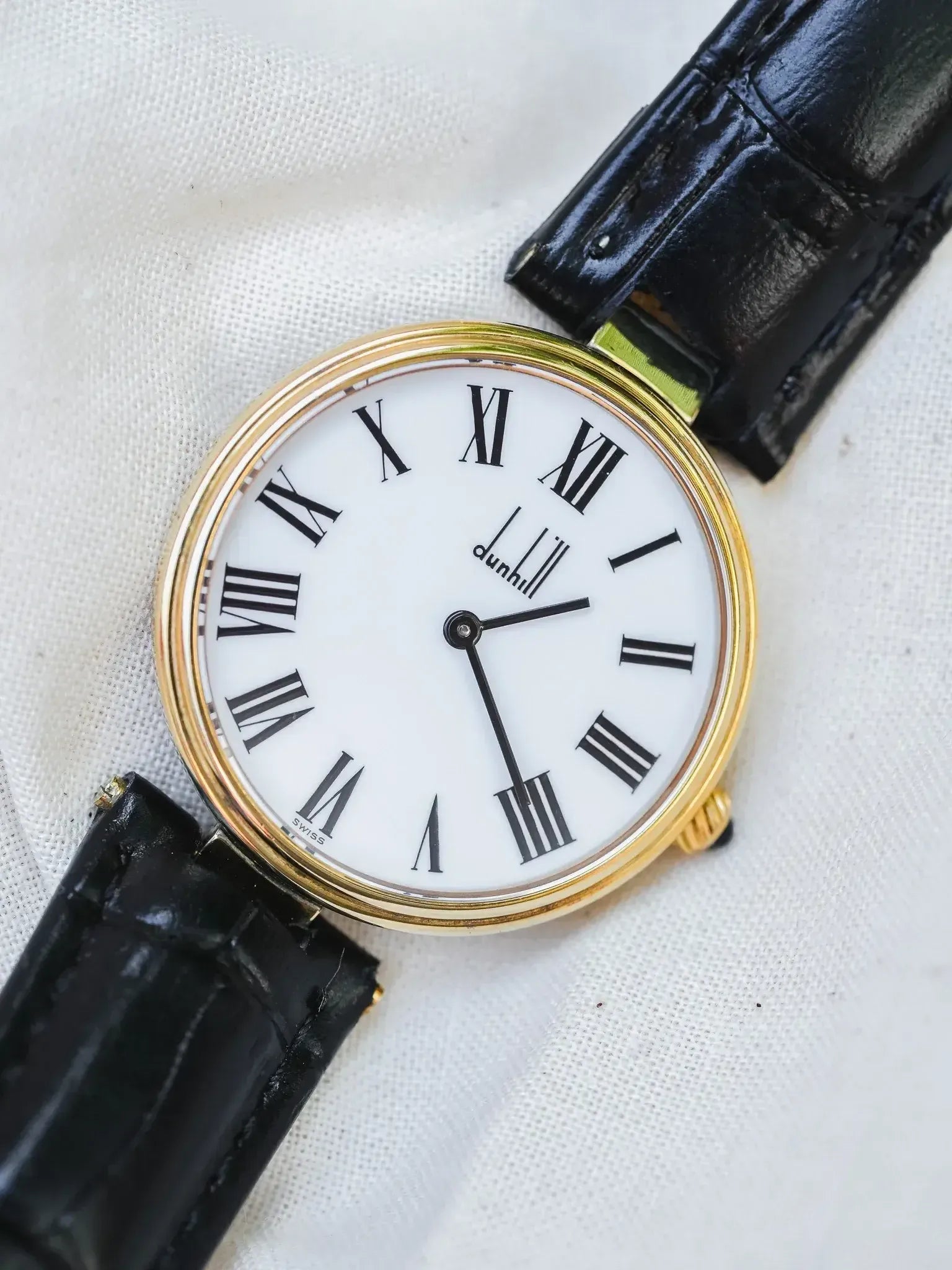 Dunhill vintage watch with gold case, white dial, Roman numerals, black alligator strap