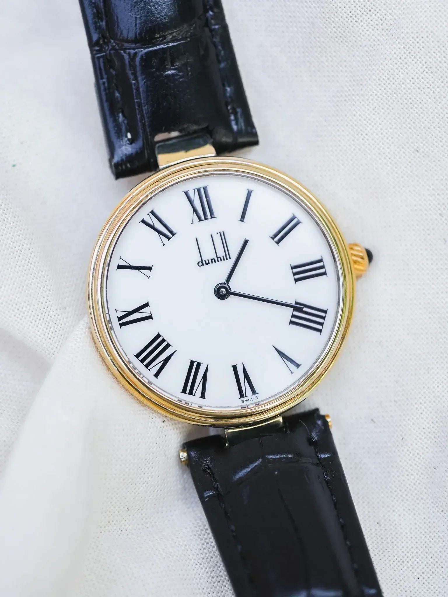 Dunhill vintage watch with gold case, white dial, Roman numerals, black alligator strap