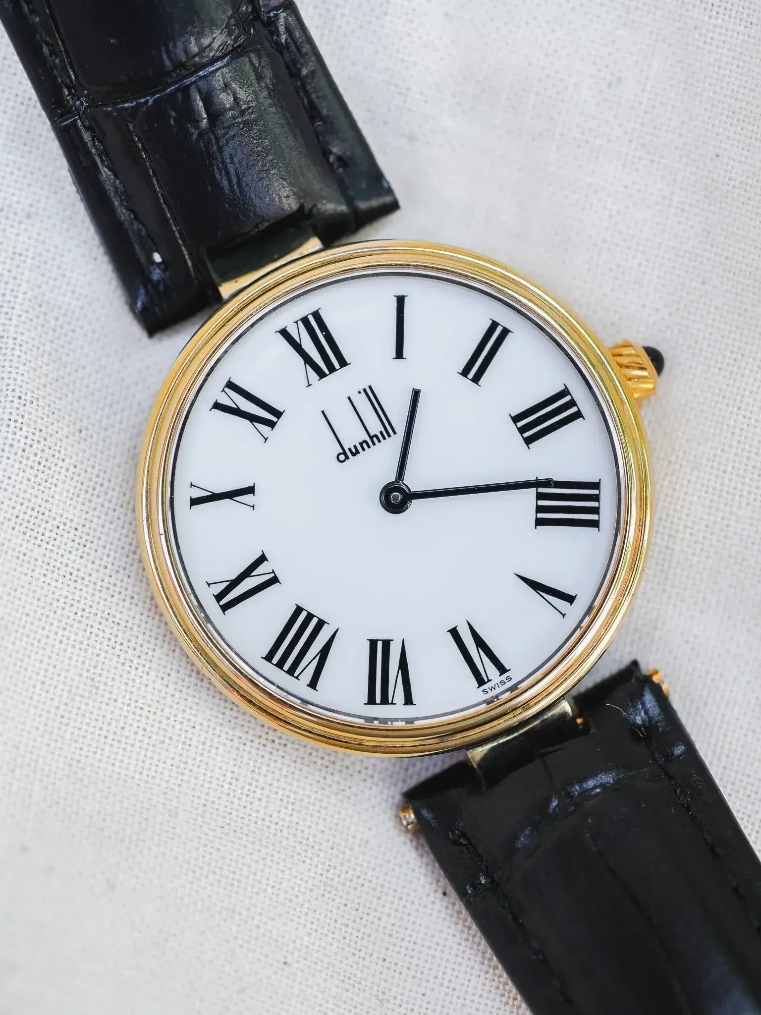 Dunhill vintage watch with gold case, white dial, Roman numerals, black leather strap