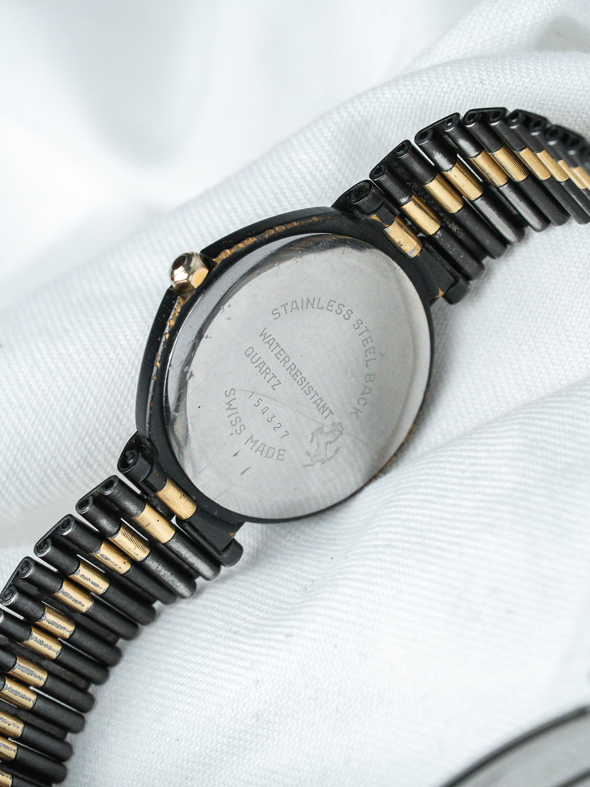 Vintage watch with stainless steel back, black and gold bracelet, Swiss made