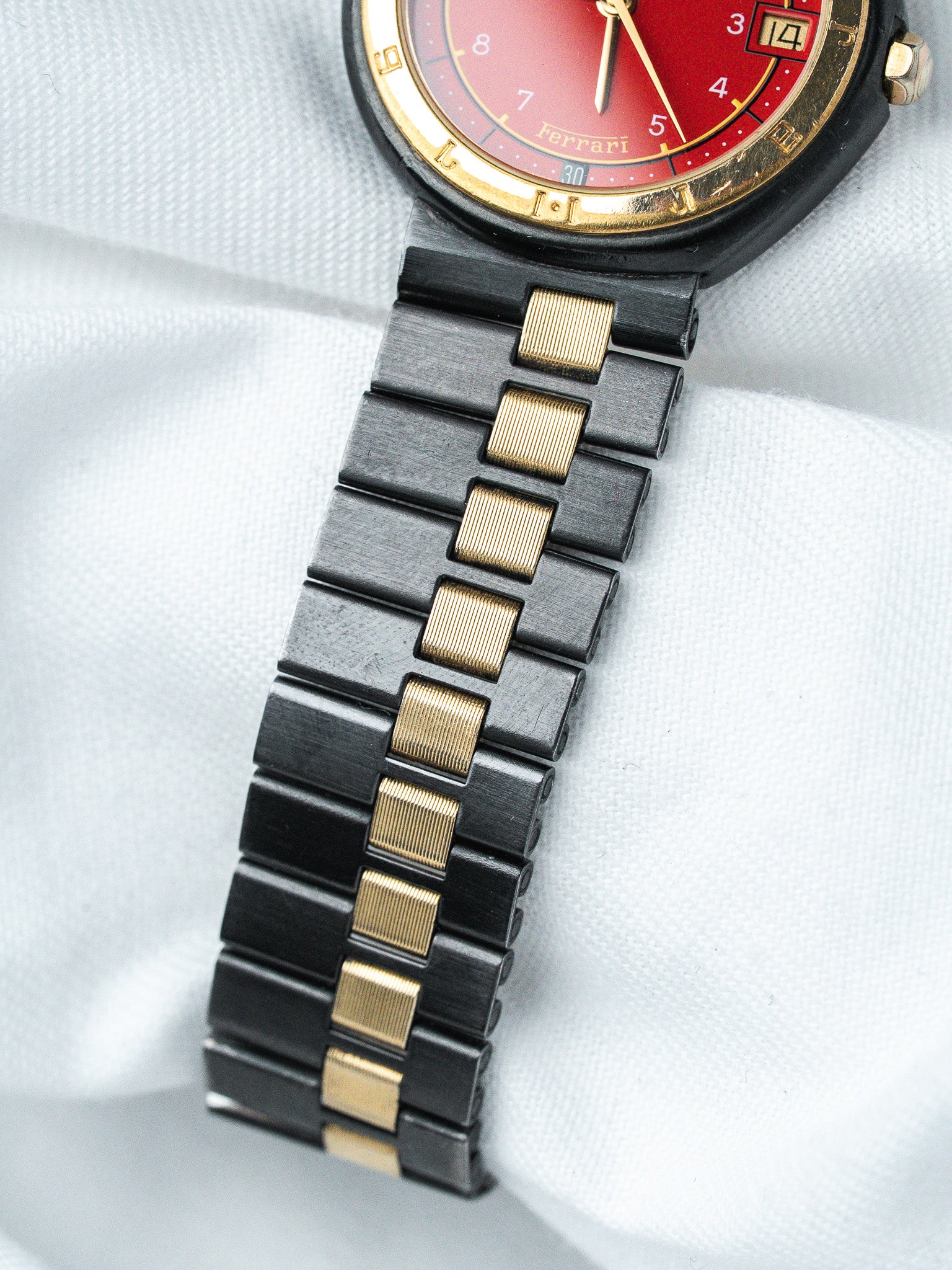 Ferrari vintage watch with red dial, gold accents, black and gold bracelet
