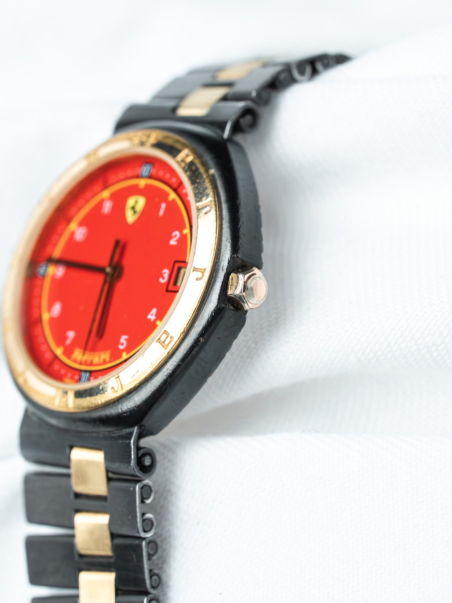 Ferrari vintage watch with red dial, gold bezel, black and gold bracelet