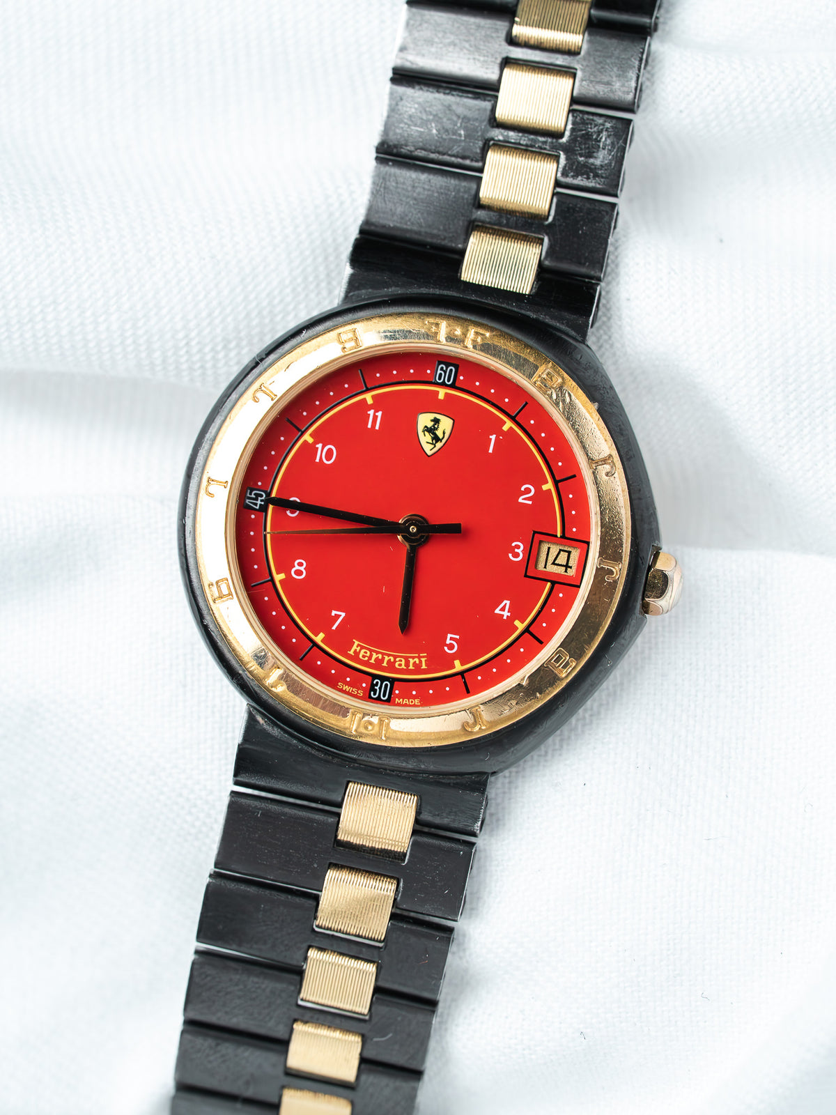 Ferrari vintage watch with red dial, gold bezel, black and gold bracelet