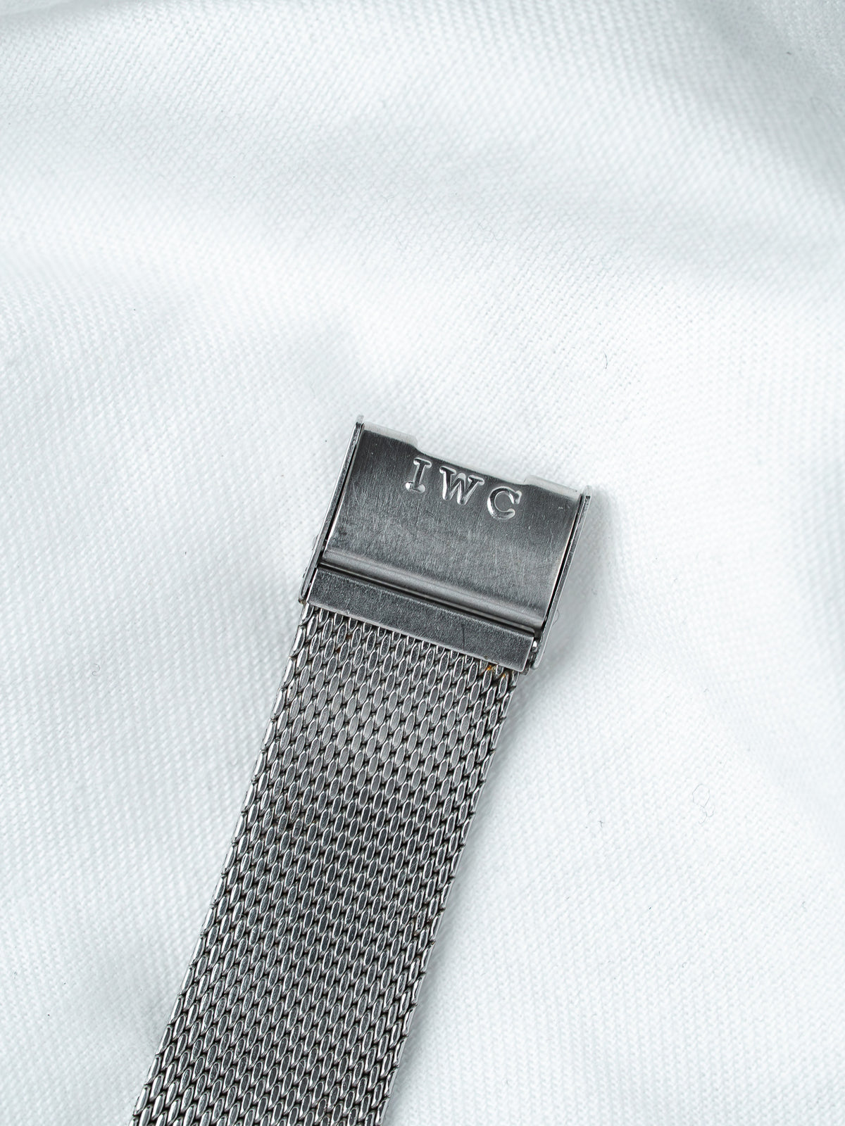 IWC watch with mesh bracelet and engraved clasp on white background
