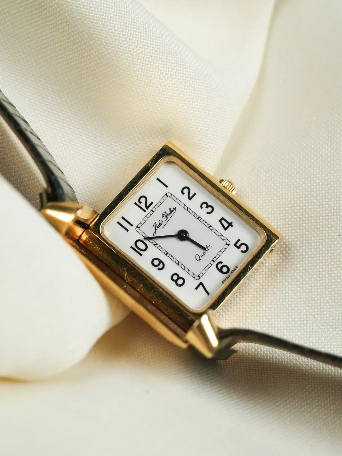 Jules Jurgensen vintage quartz watch, gold case, white dial, black leather strap on fabric
