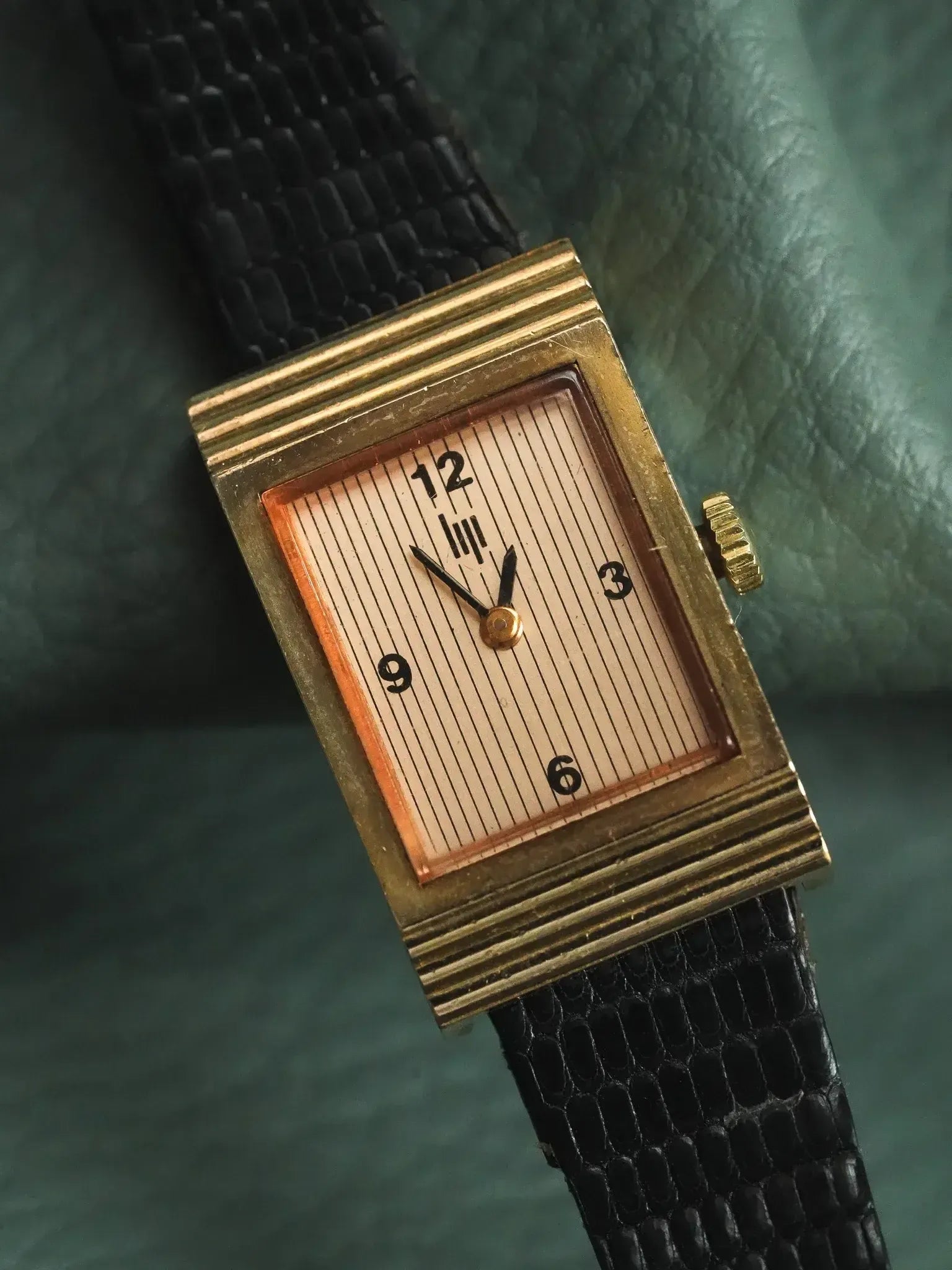 Vintage rectangular gold watch with striped cream dial and black leather strap