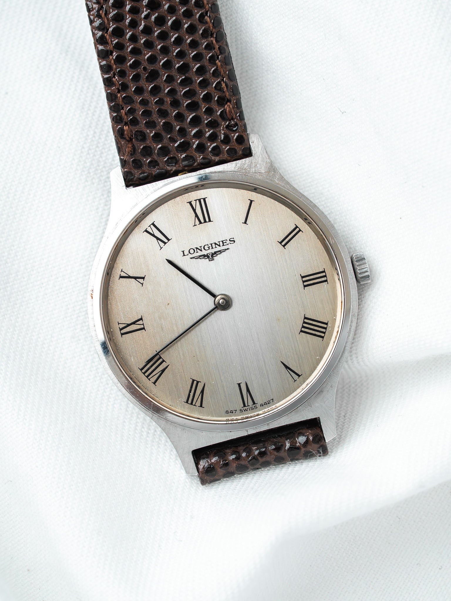 Longines vintage watch with silver dial, Roman numerals, brown textured strap