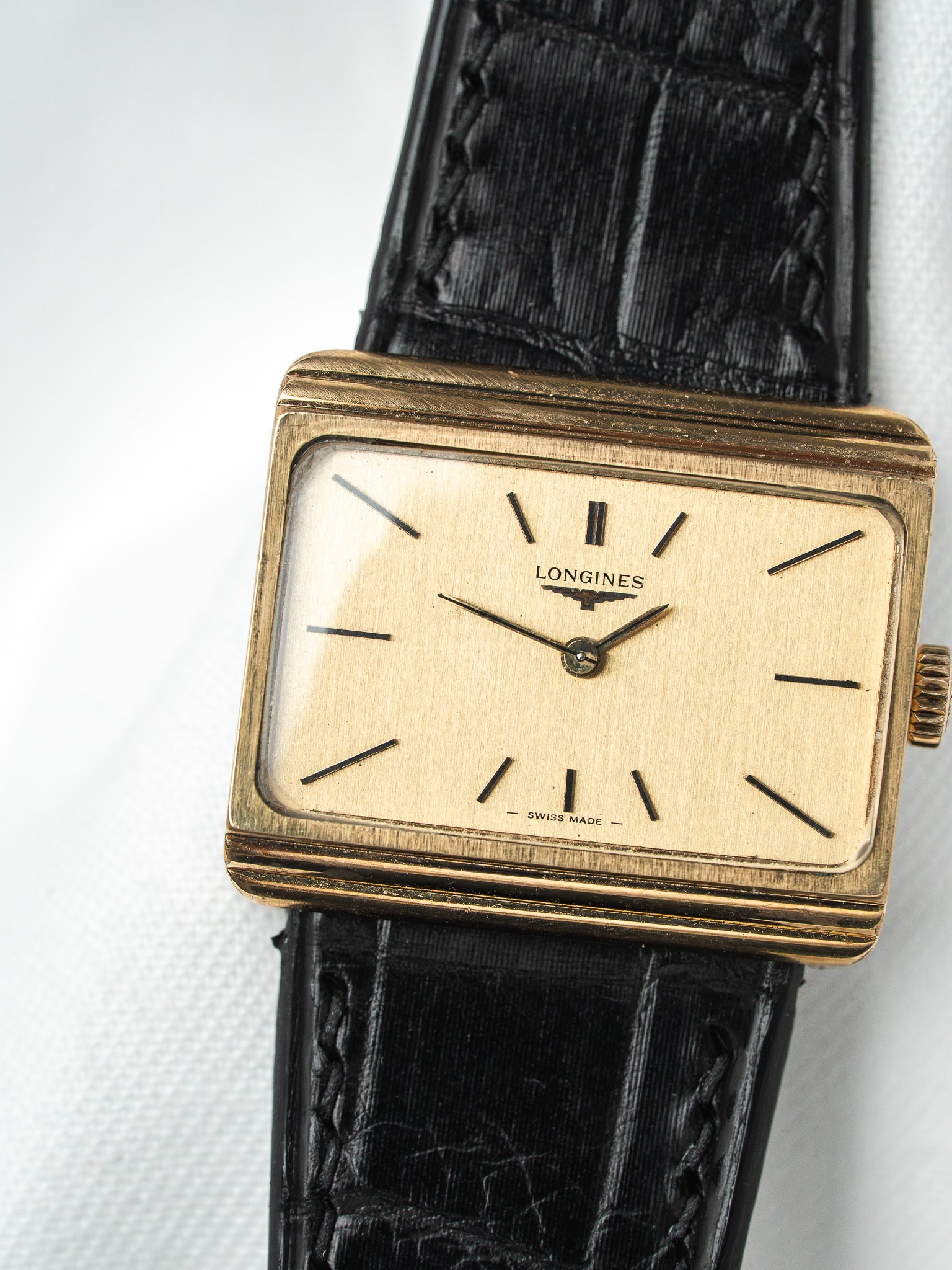 Longines vintage watch with gold case, cream dial, black leather strap