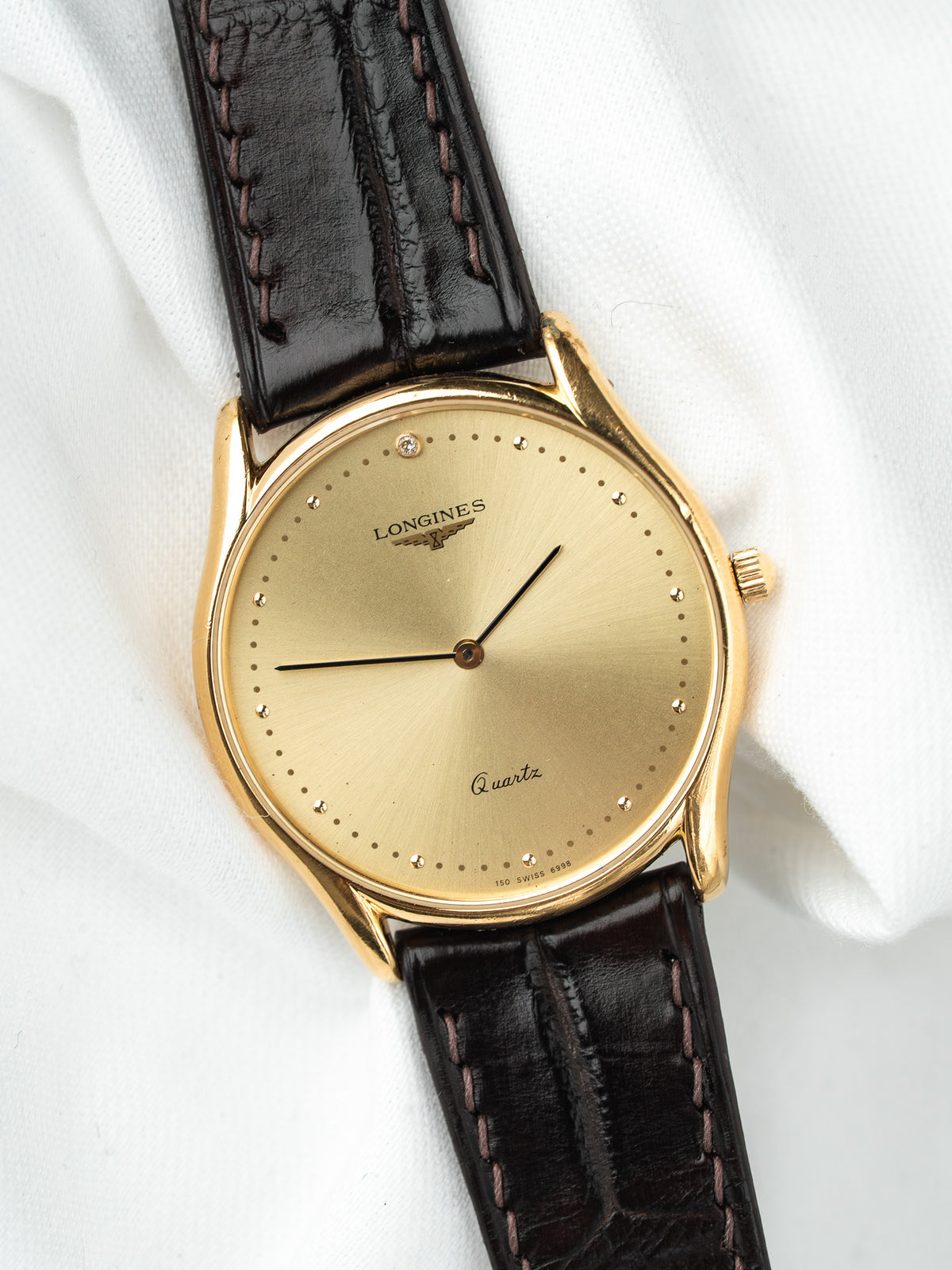Montre Longines vintage, boîtier rond en or, cadran doré et bracelet cuir noir