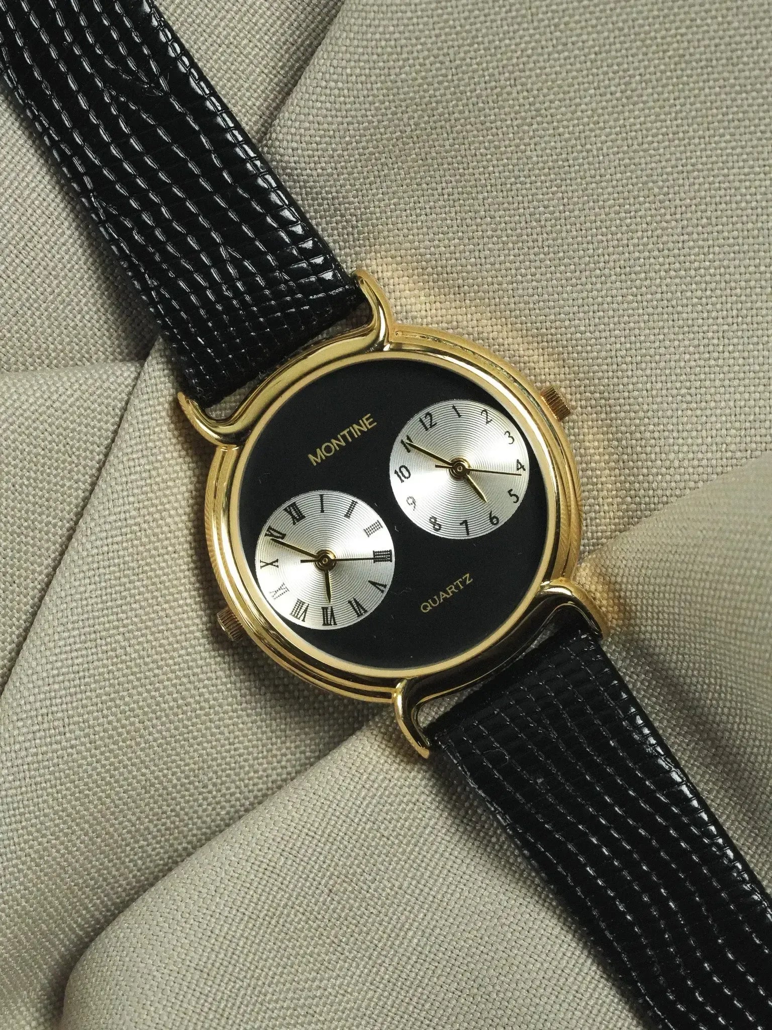Montine vintage watch with gold case, black dial, dual silver subdials, and black leather strap