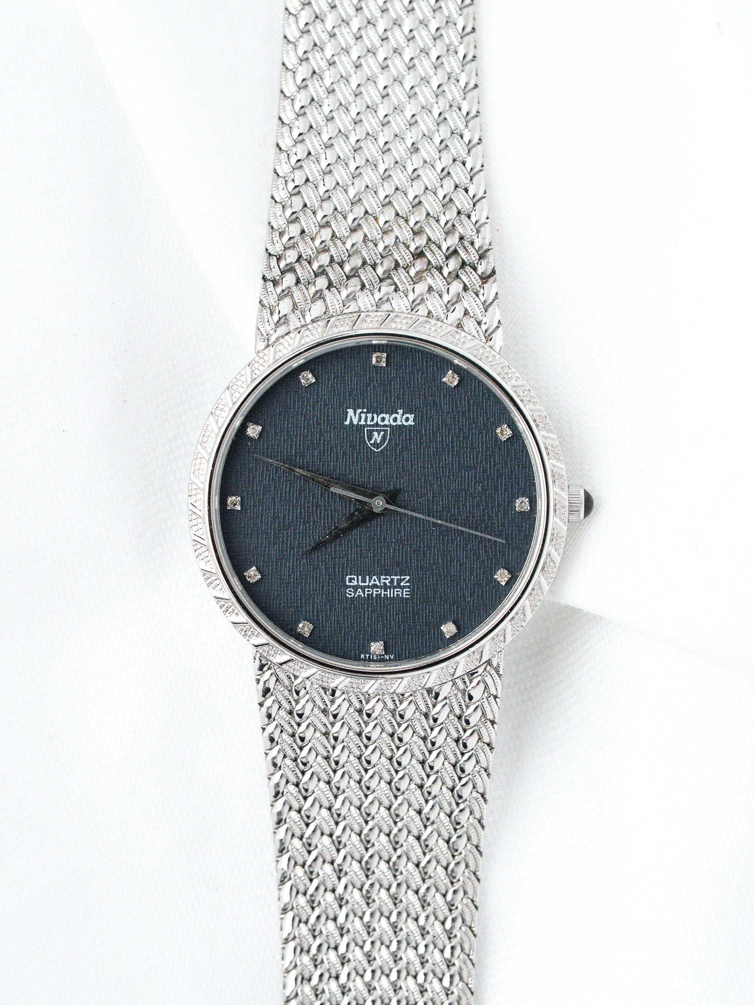 Nivada vintage watch with blue dial, diamond markers, and mesh bracelet on white background