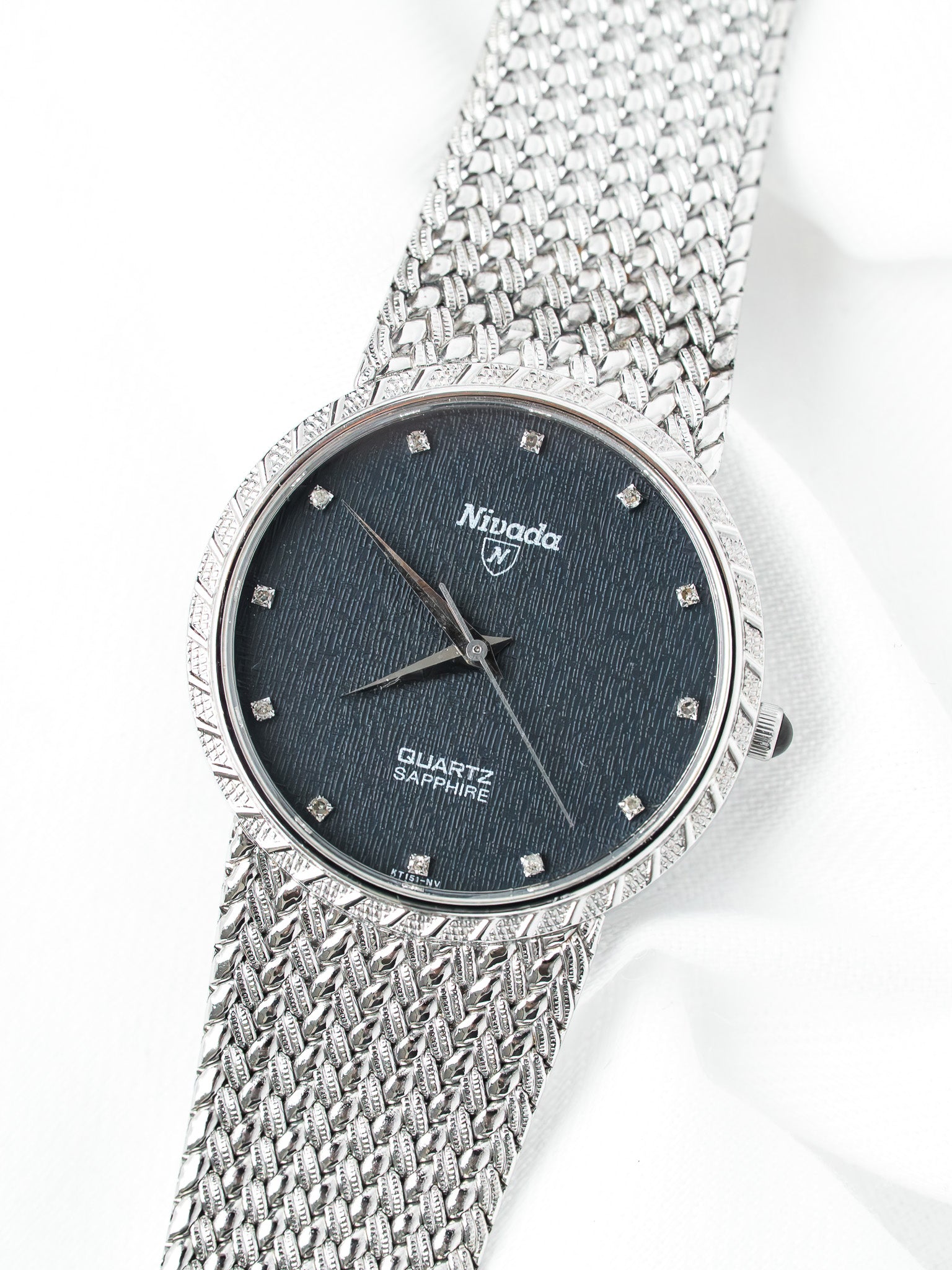 Nivada vintage watch with dark textured dial, diamond hour markers, and intricate mesh bracelet