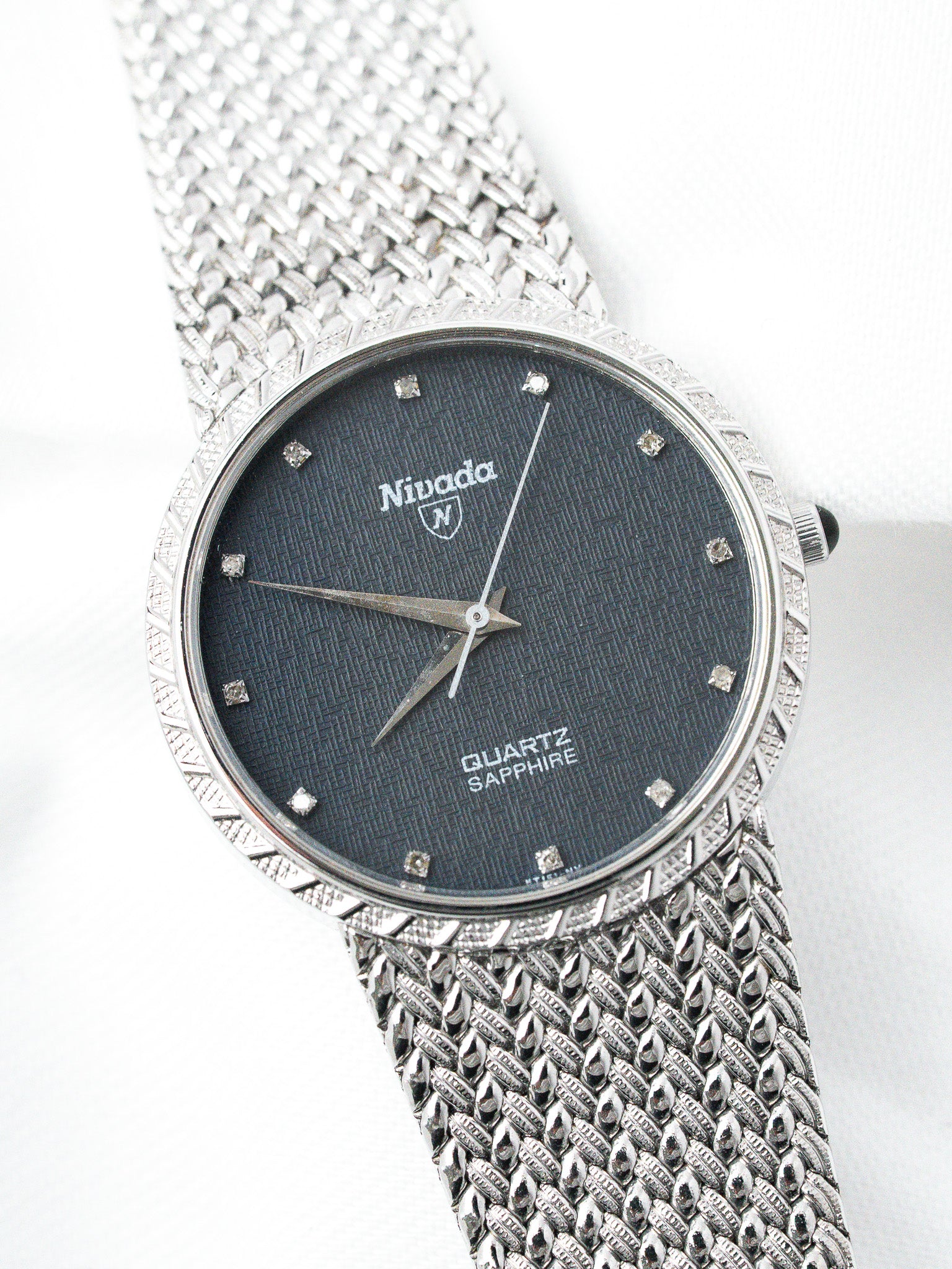 Nivada vintage quartz watch with diamond hour markers, textured black dial, and mesh bracelet