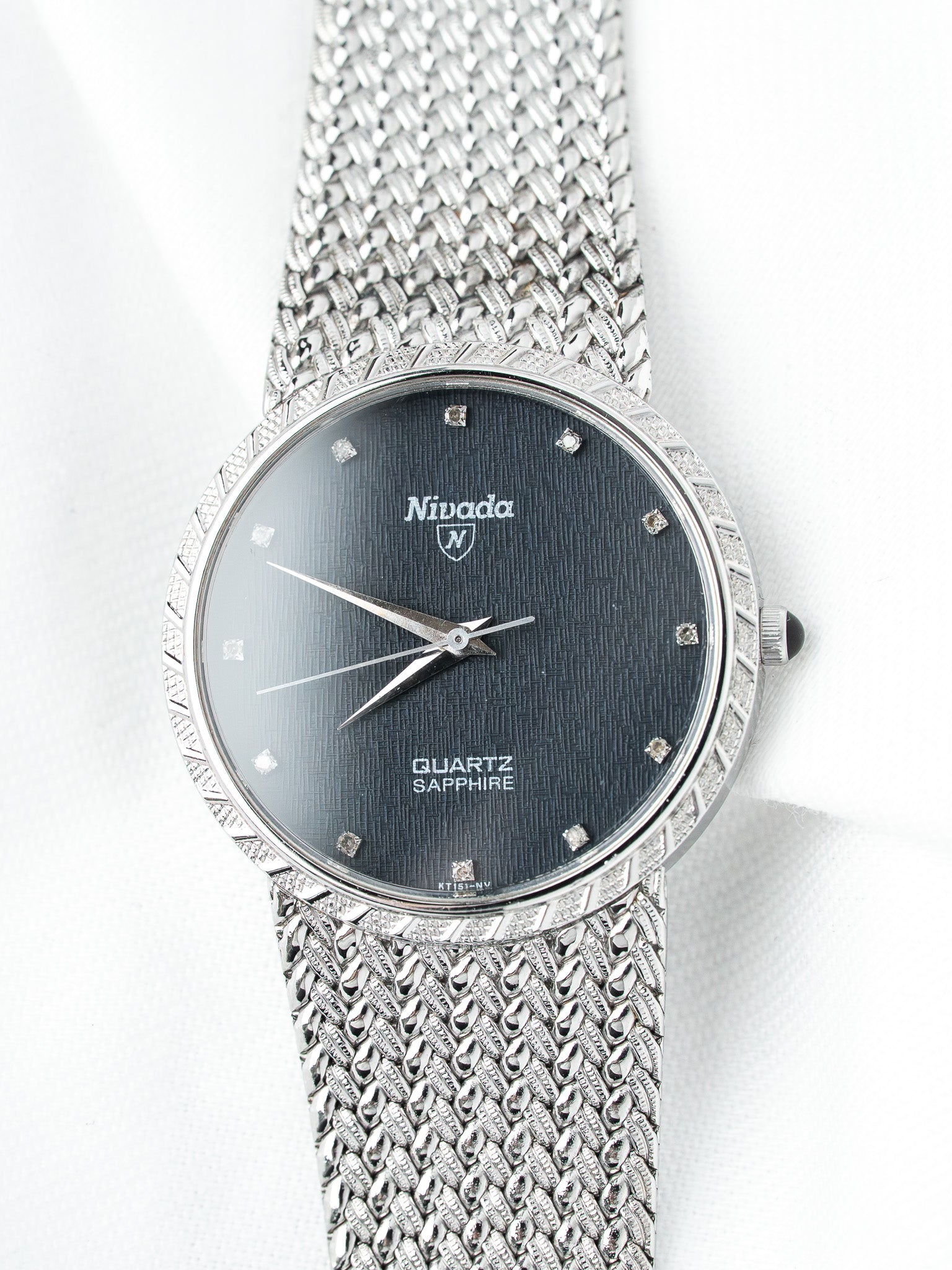 Nivada vintage watch with black textured dial, diamond markers, and mesh bracelet