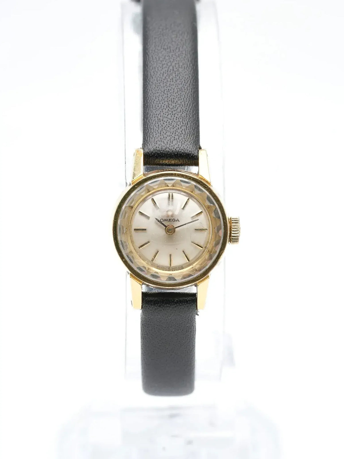 Vintage Omega watch with gold case, white dial, black leather strap on display