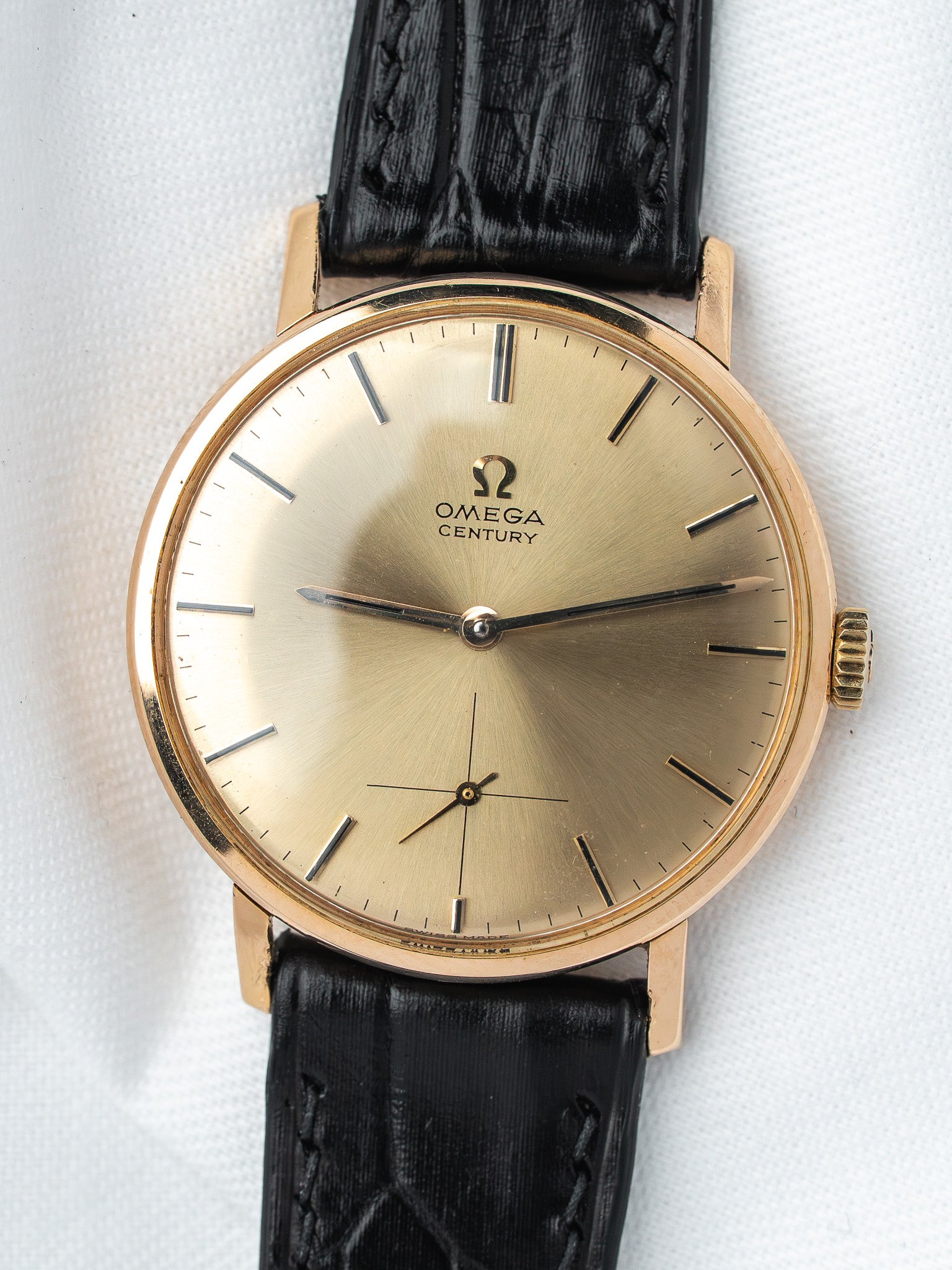 Omega Century vintage watch with gold case, champagne dial, black leather strap